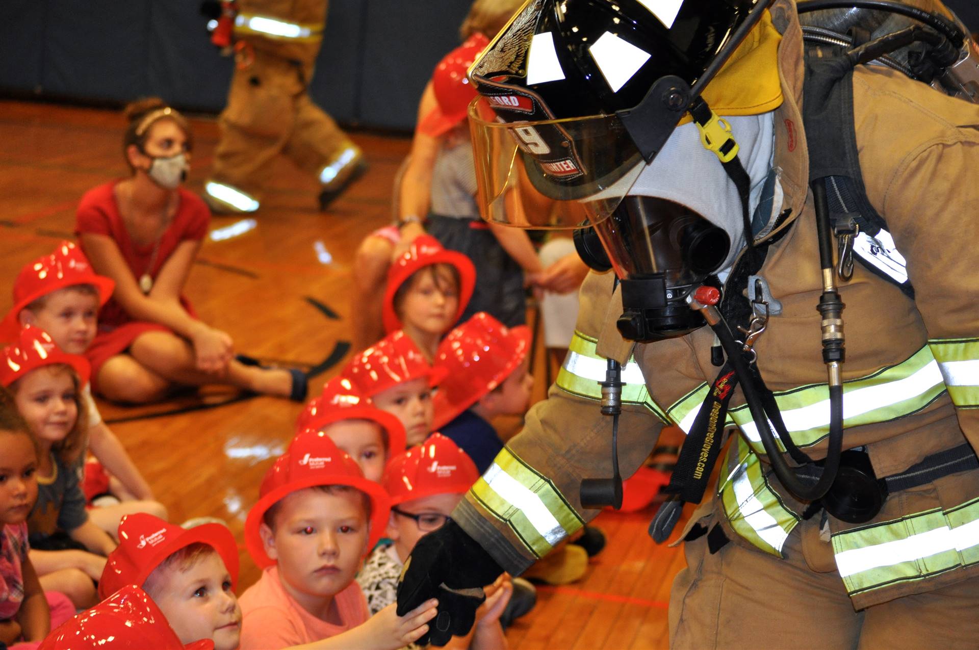 students and firefighter at fire safety assembly.