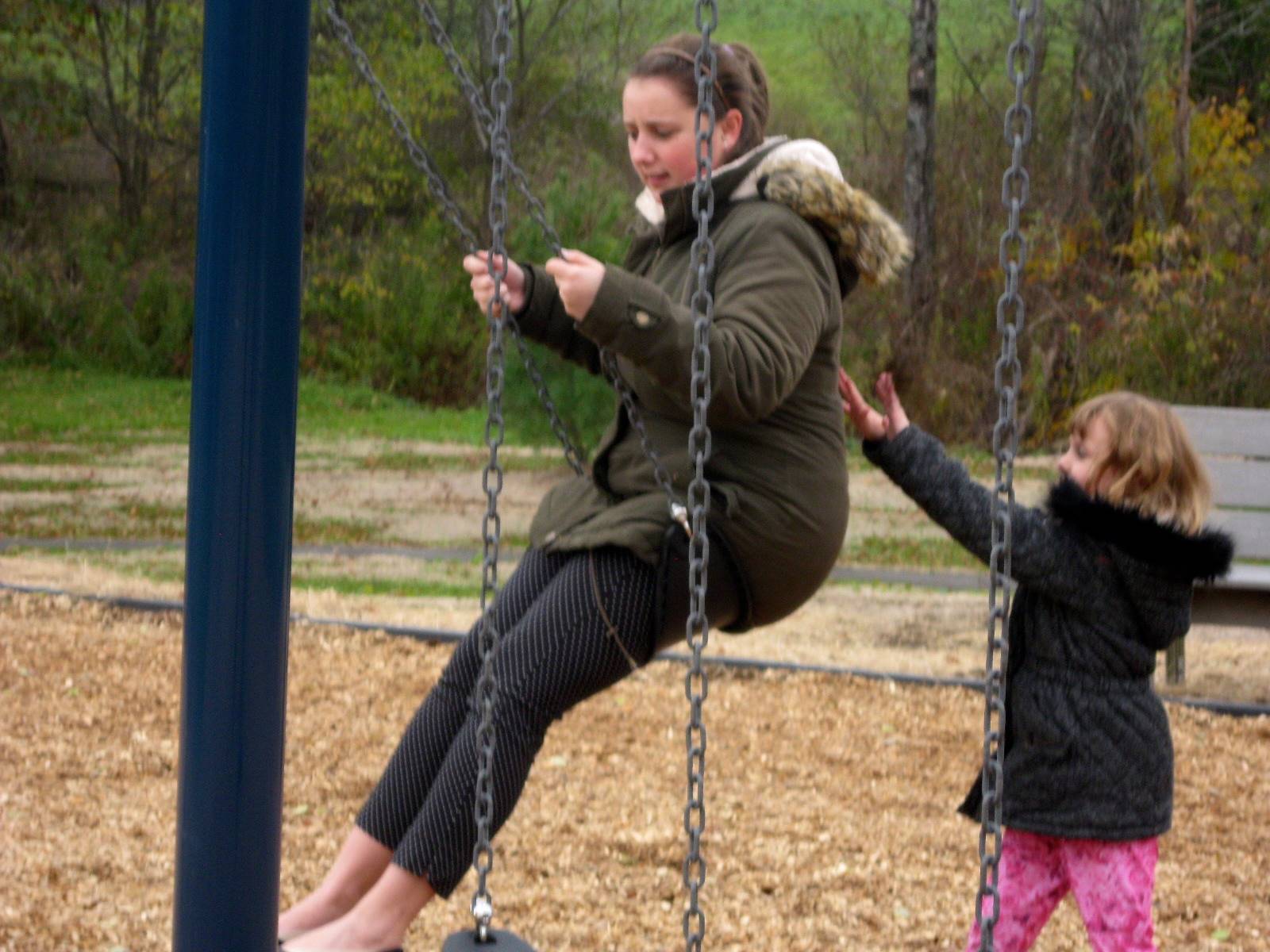 The Guilford playground is open! A child pushes a teacher on the swing. 