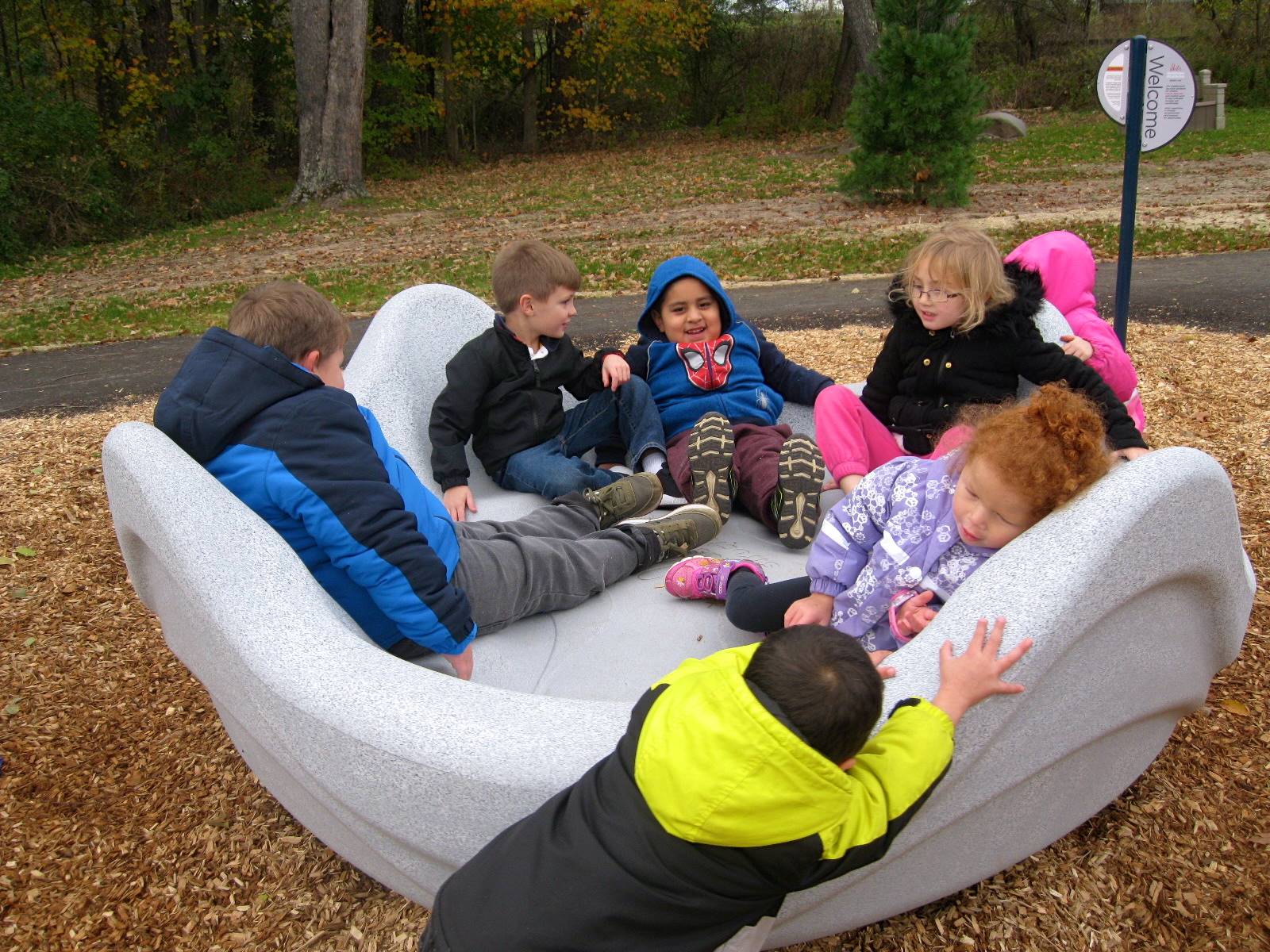 Kids play on the giant clam merry go round.