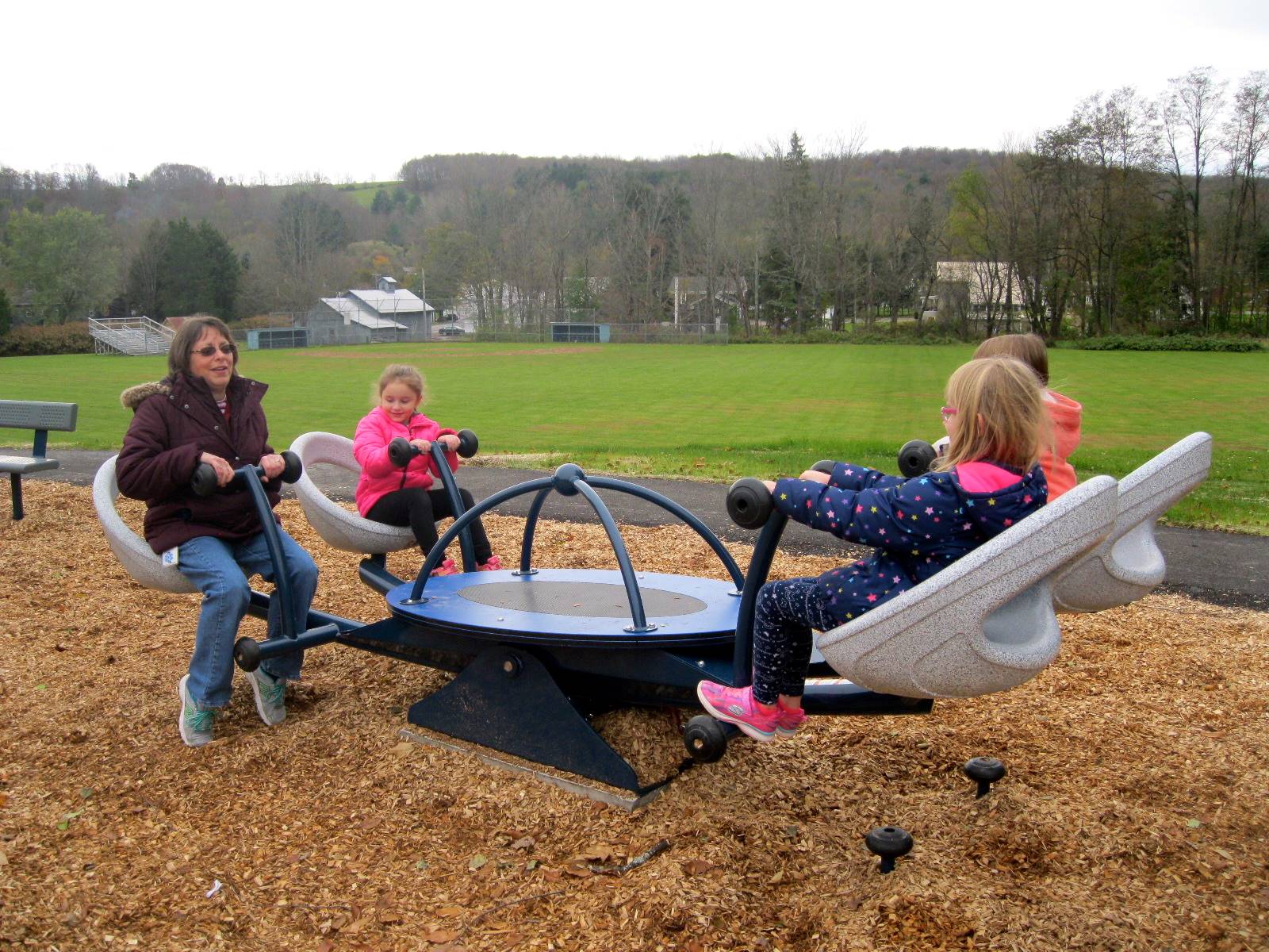 Kids try out the new teeter totter. There is an adult on there too!