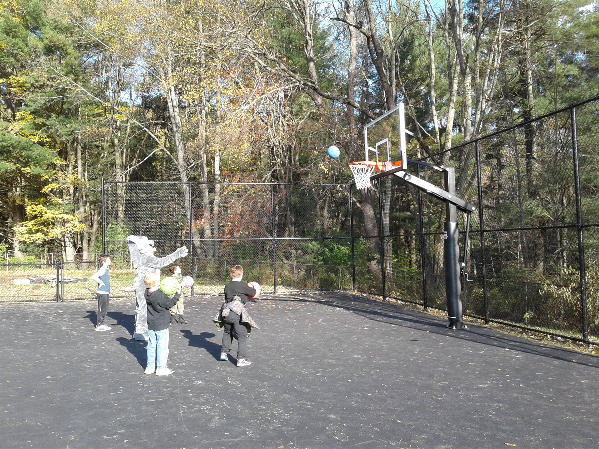 Felix the Bobcat with students on the playground