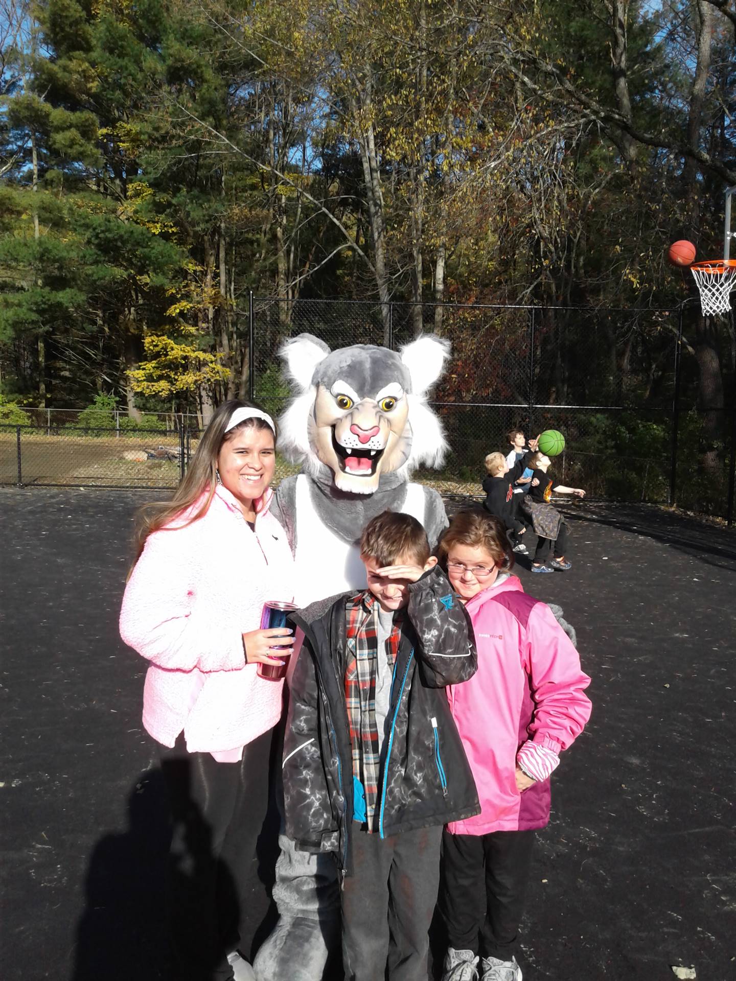 Felix the Bobcat with students on the playground