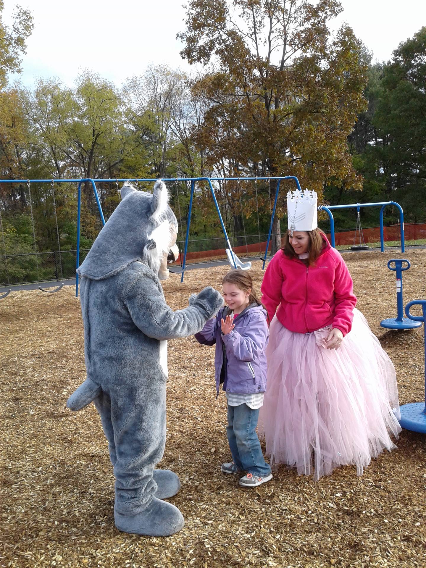 Felix the Bobcat with students on the playground