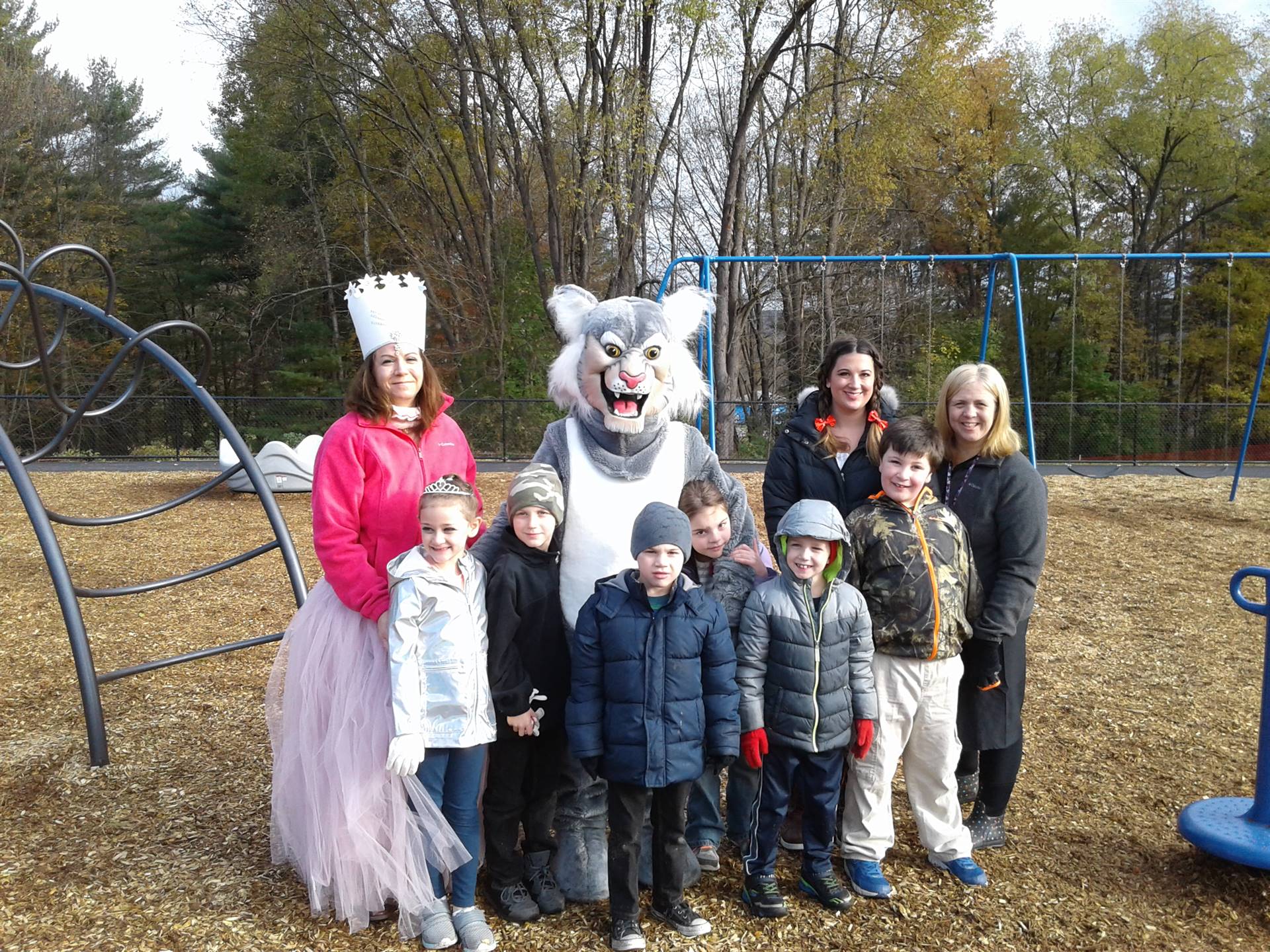 Felix the Bobcat with students on the playground