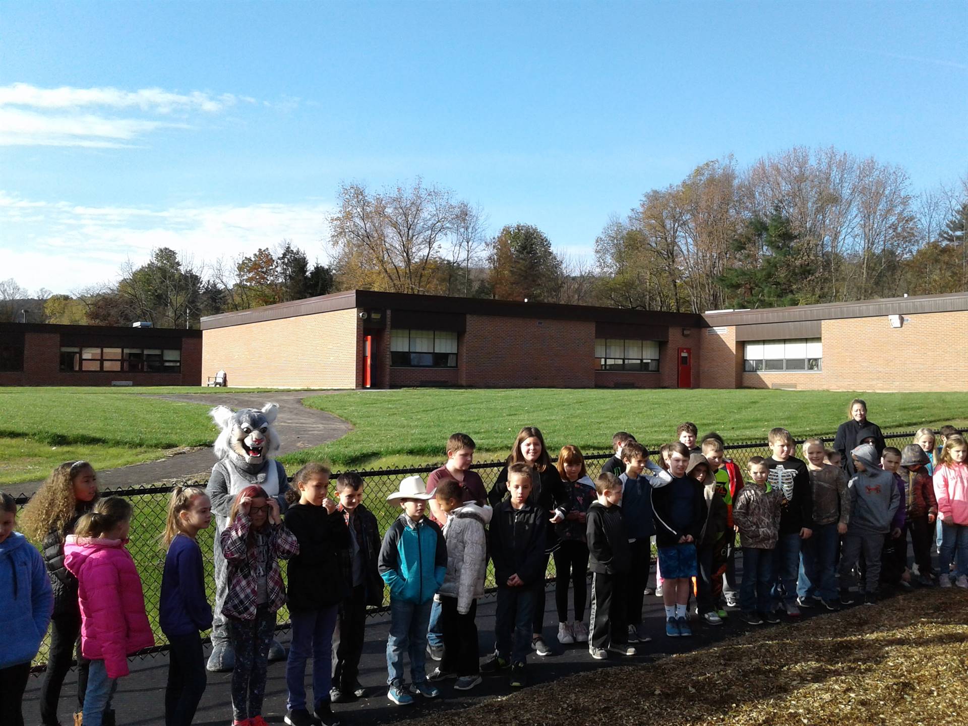 Felix the Bobcat with students on the playground