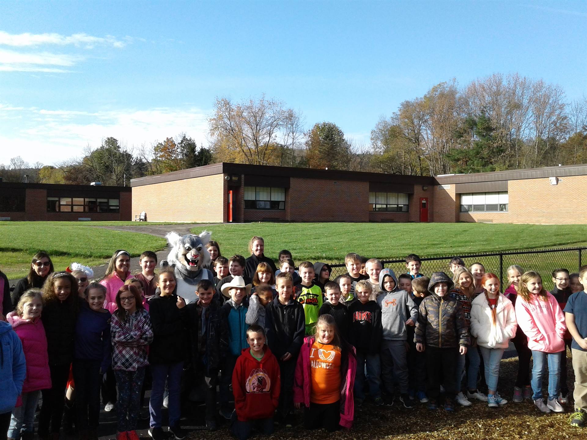 Felix the Bobcat with students on the playground