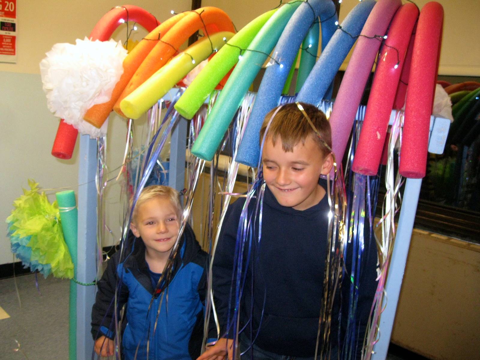 Children peek through the rainbow tunnel at the guilford open house book fair.