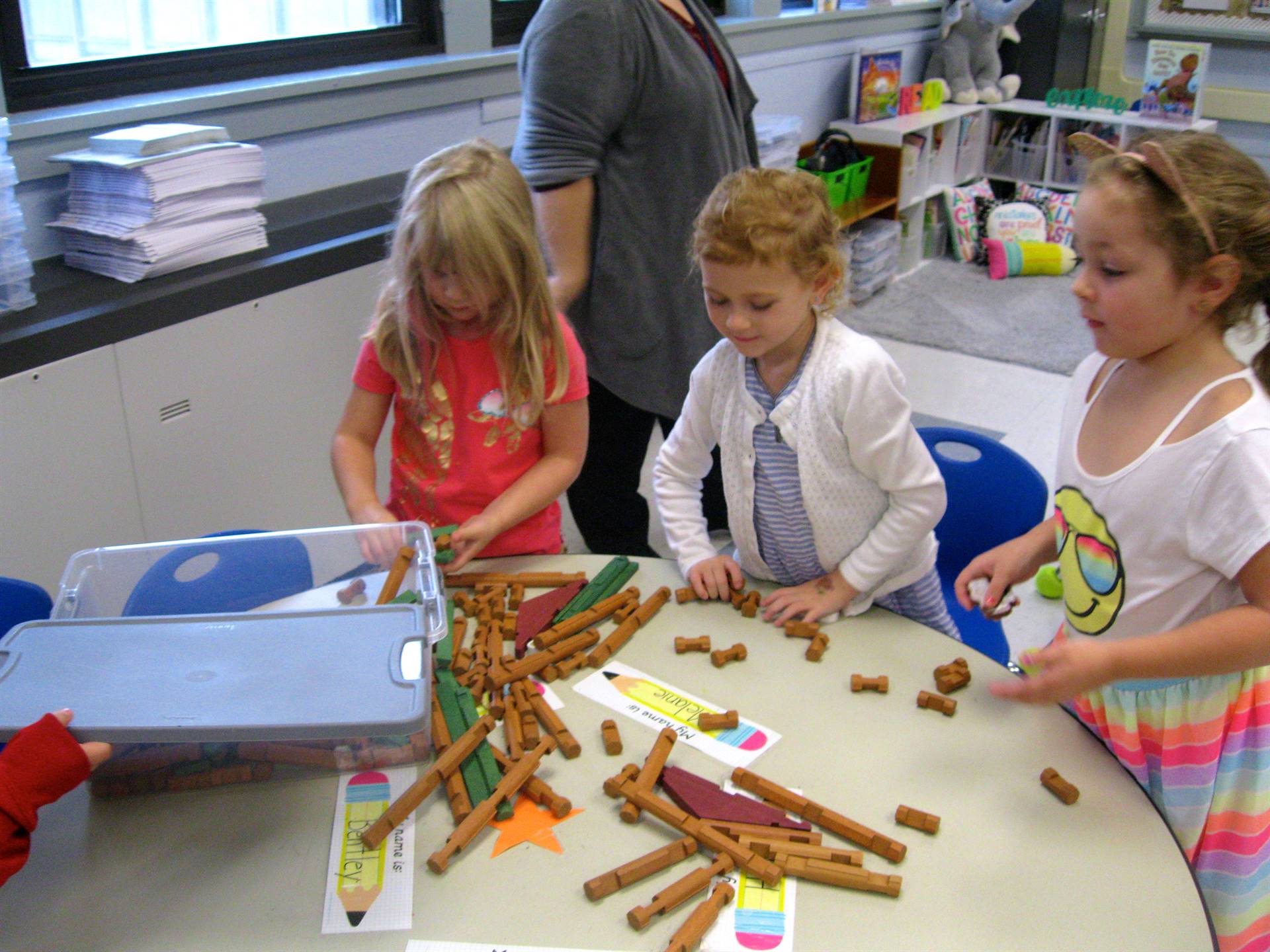 Students use helping hands to pick up.