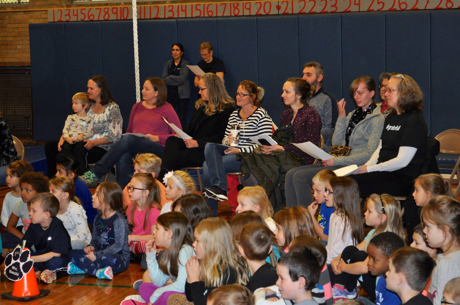 Family and students watching assembly.