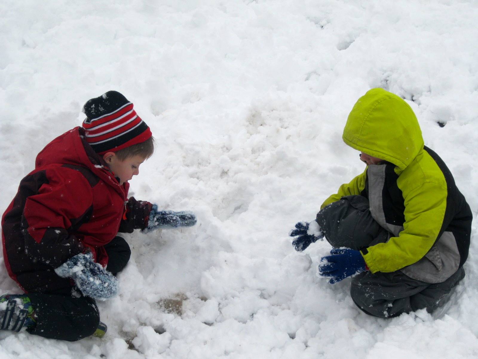 2 children building a snowman.