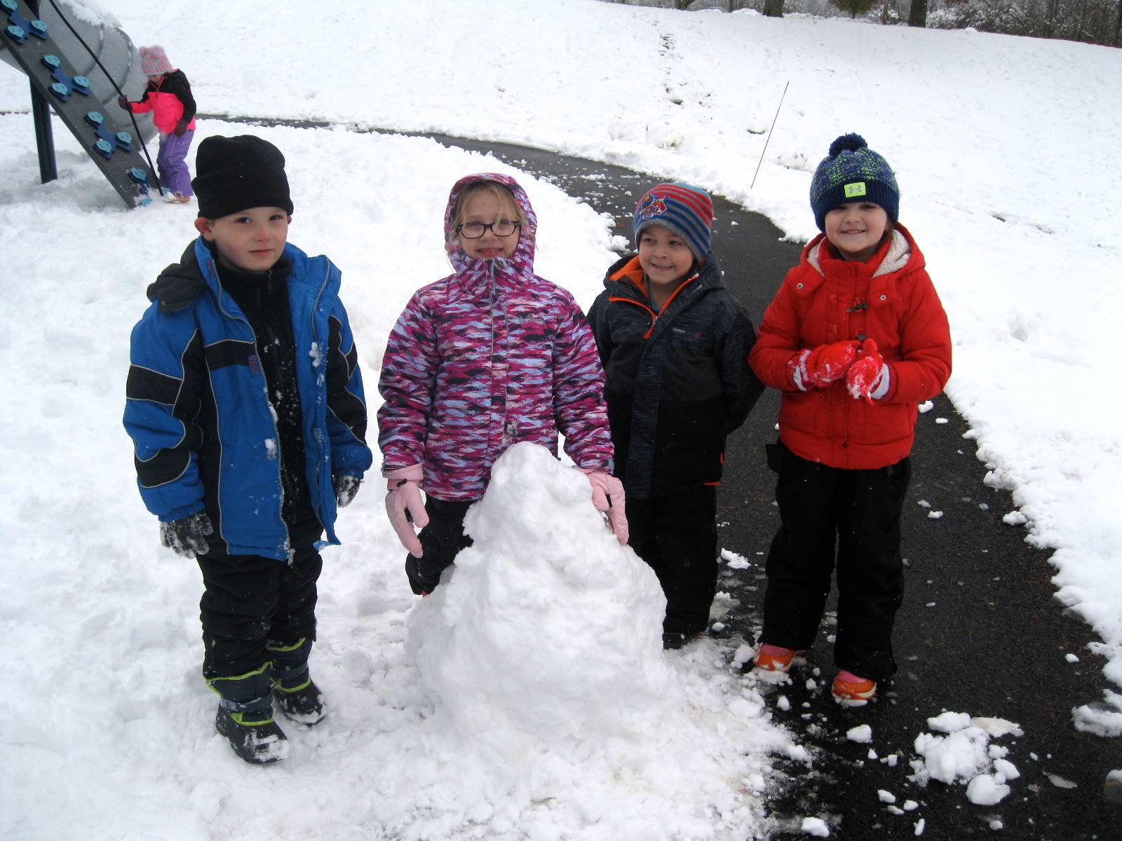 A group of children building a snowman.