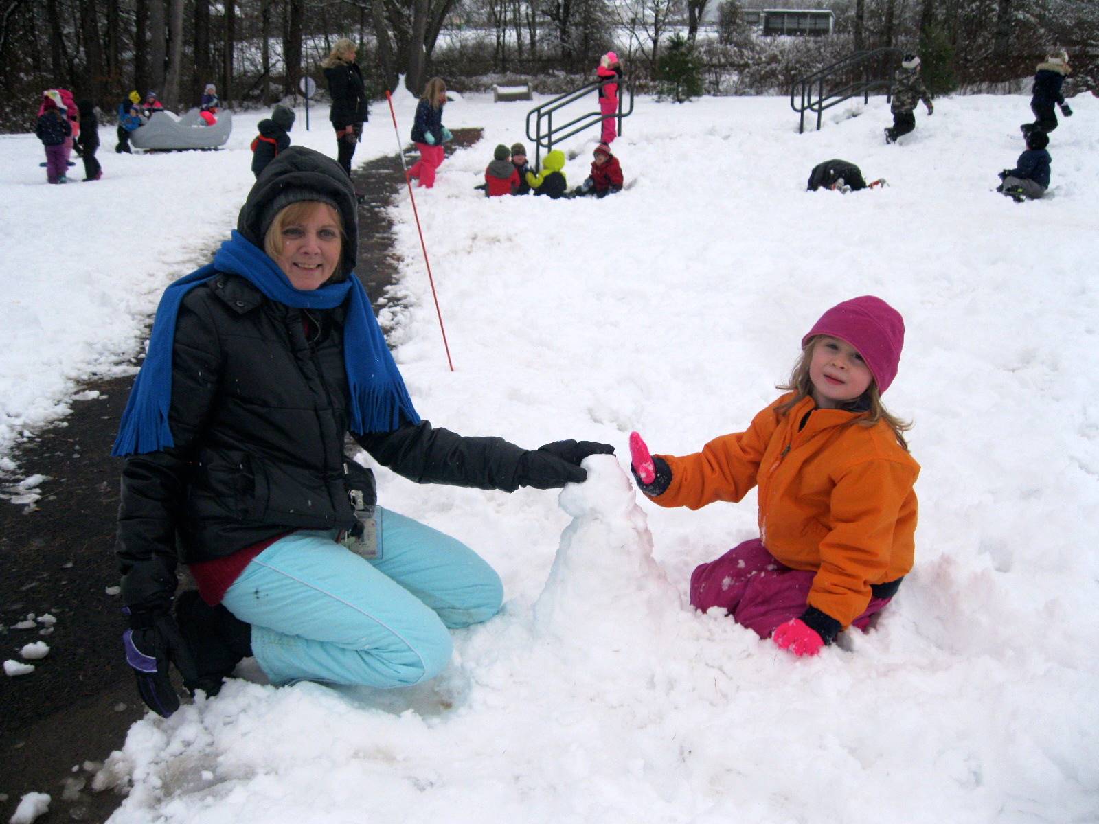 A staff member and student make a snowman!