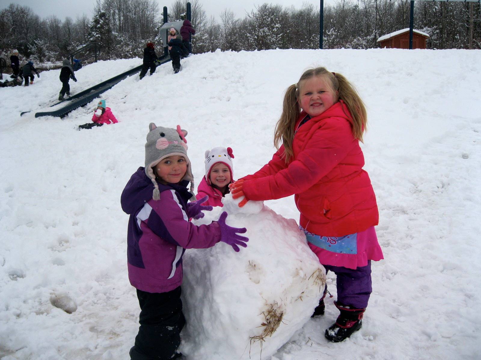 3 children building a snowman.