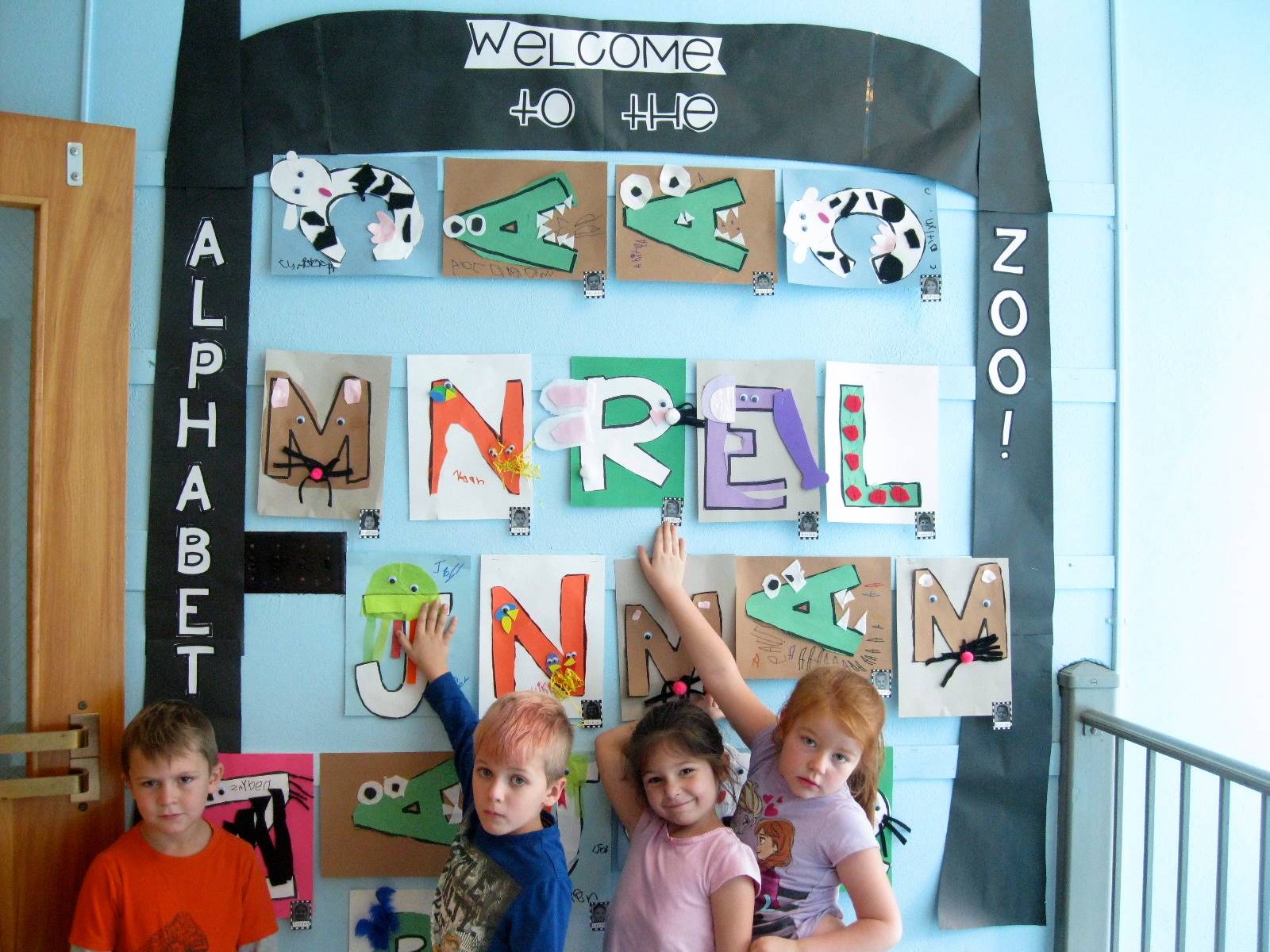 4 students show off the Zoo animals at open house.