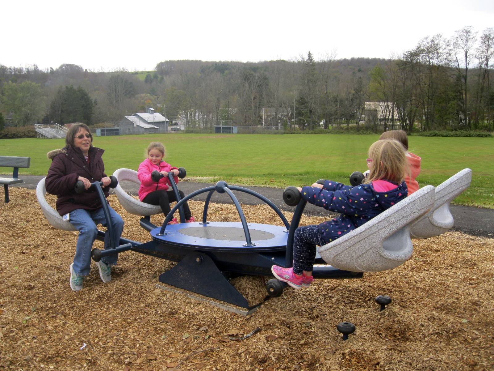 3 students and 1 adult on the teeter totter.