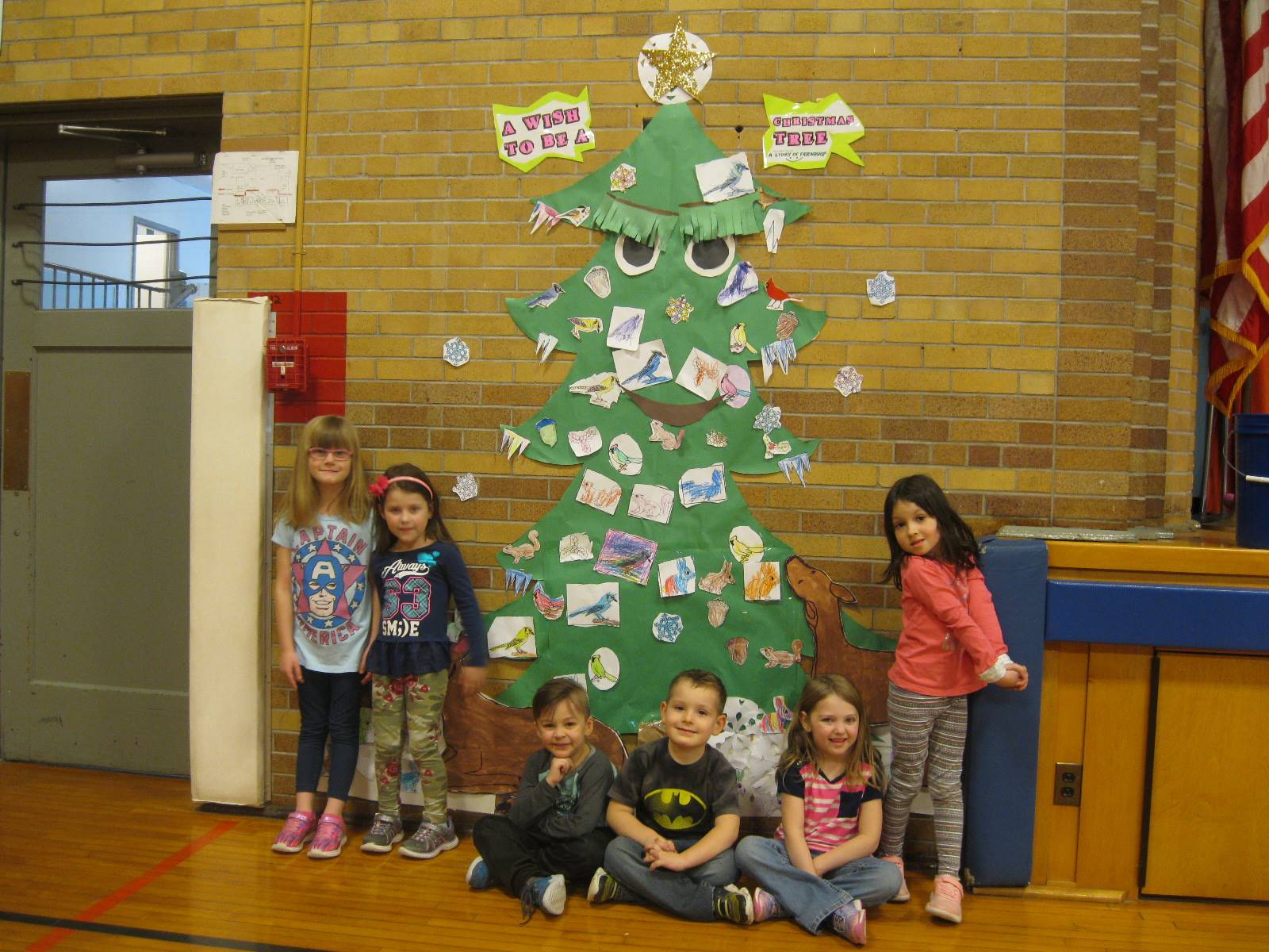 6 Students stand next to the tree they decorated with nature!