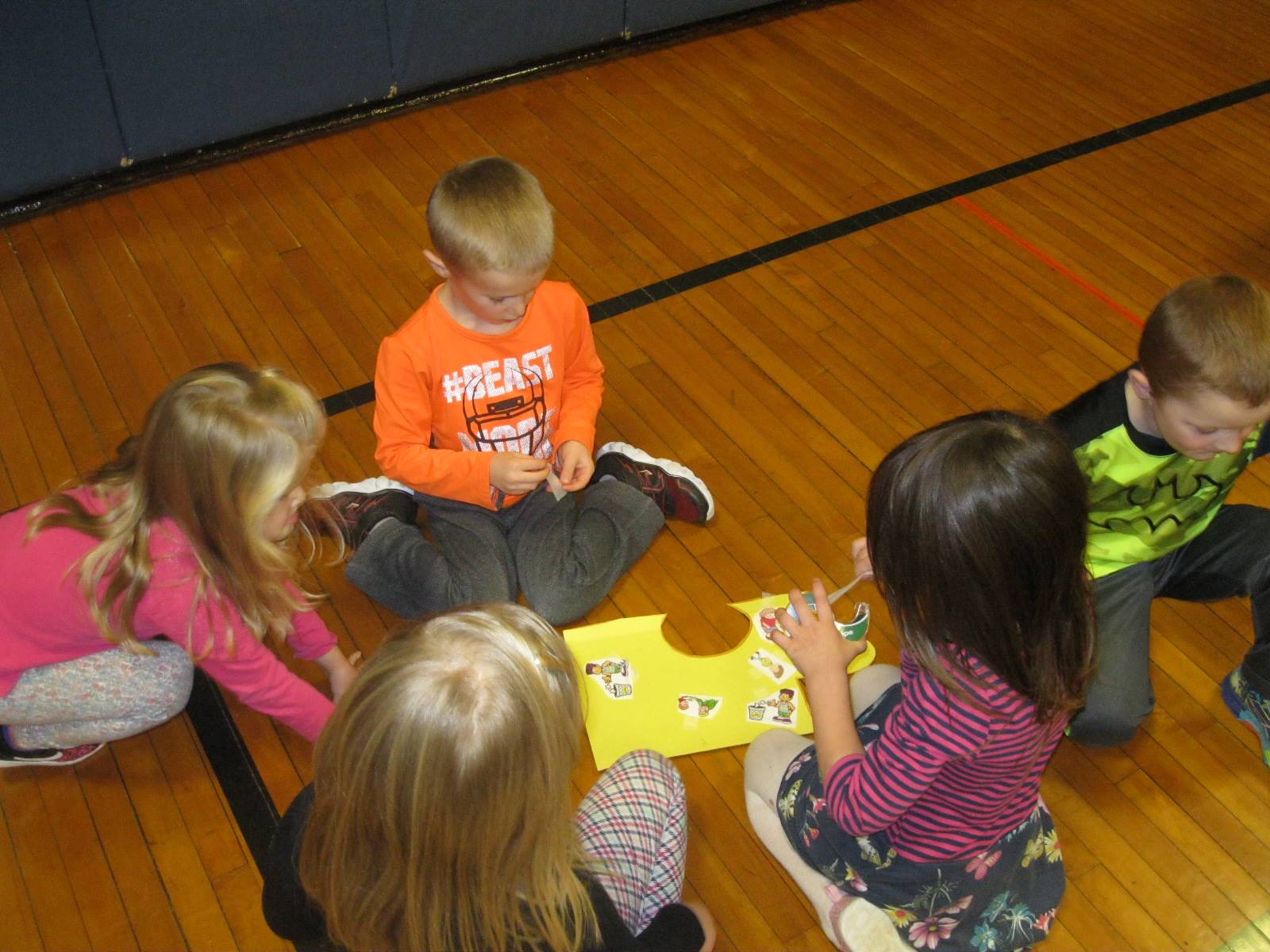 5 students work on adding responsible pictures to their puzzle piece!