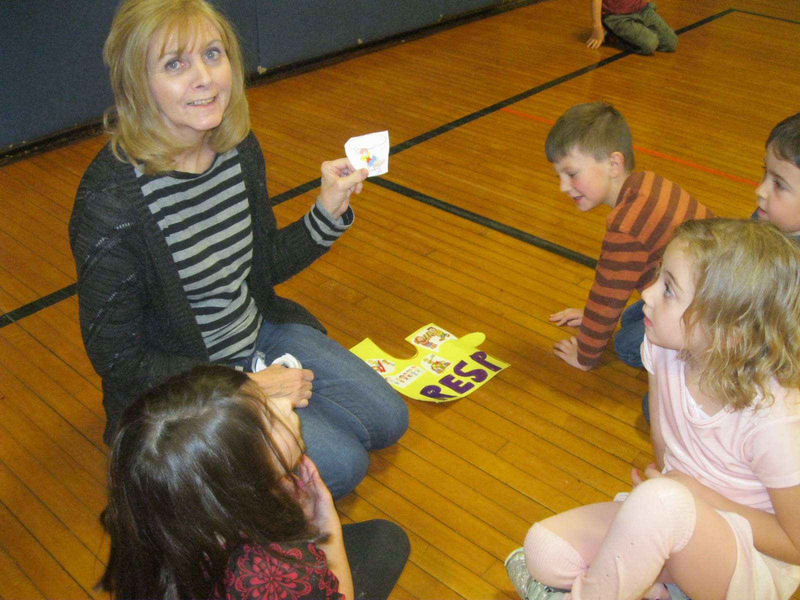 A staff member shows her students a responsible picture.