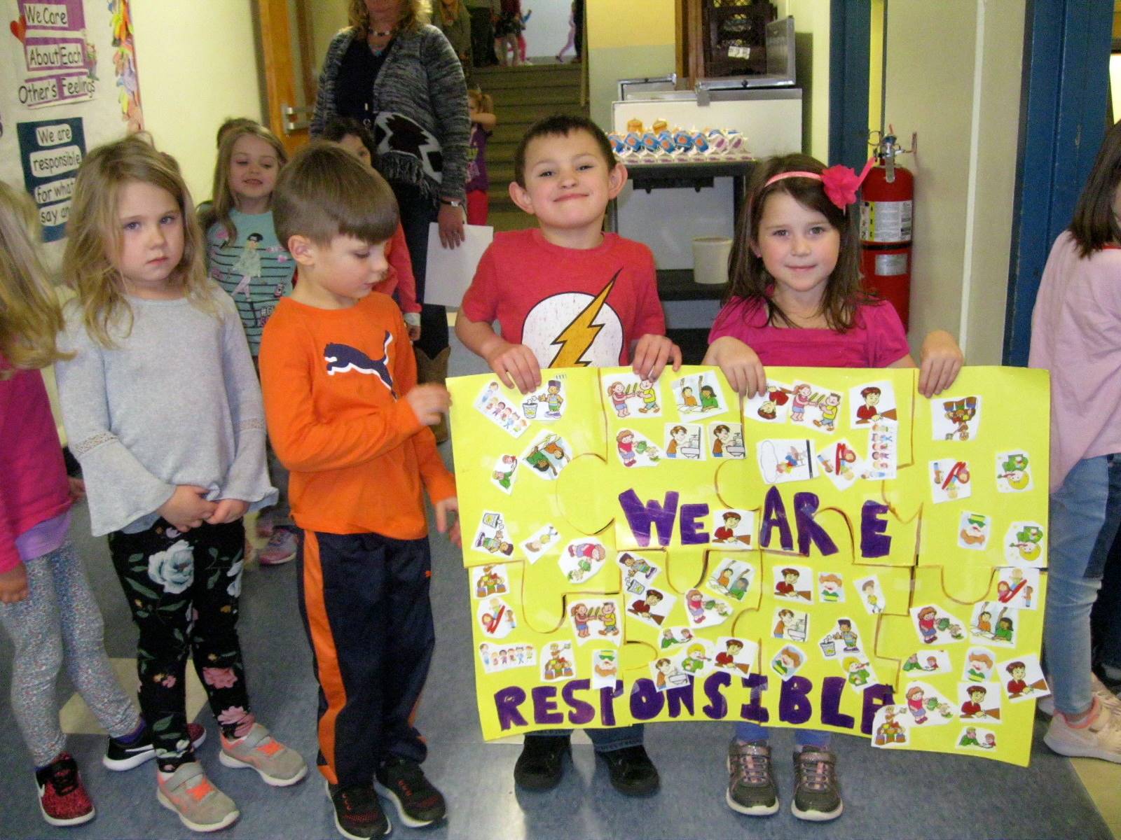 4 students with the finished puzzle, "WE ARE RESPONSIBLE".