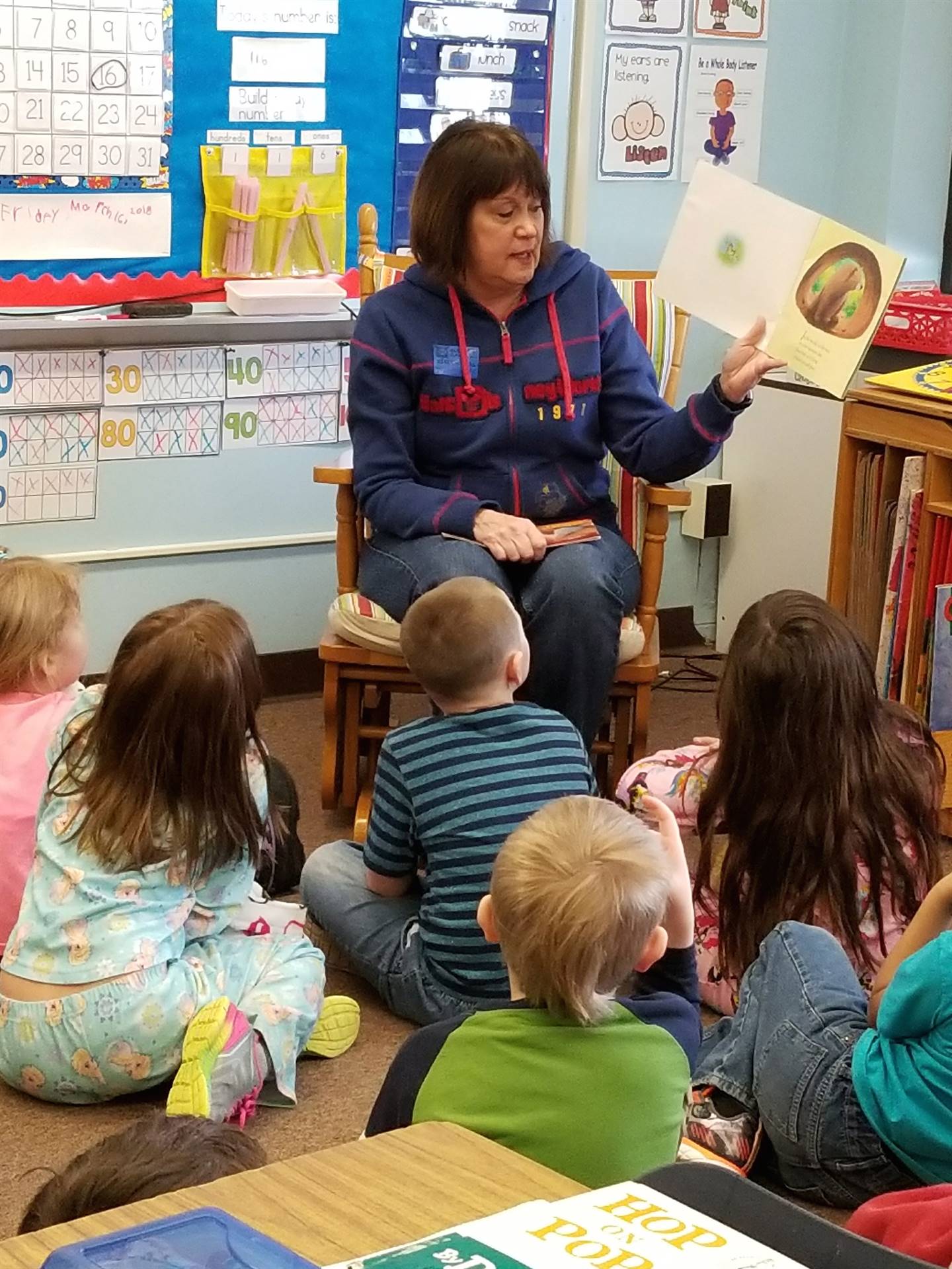 A family member reads to first grade class