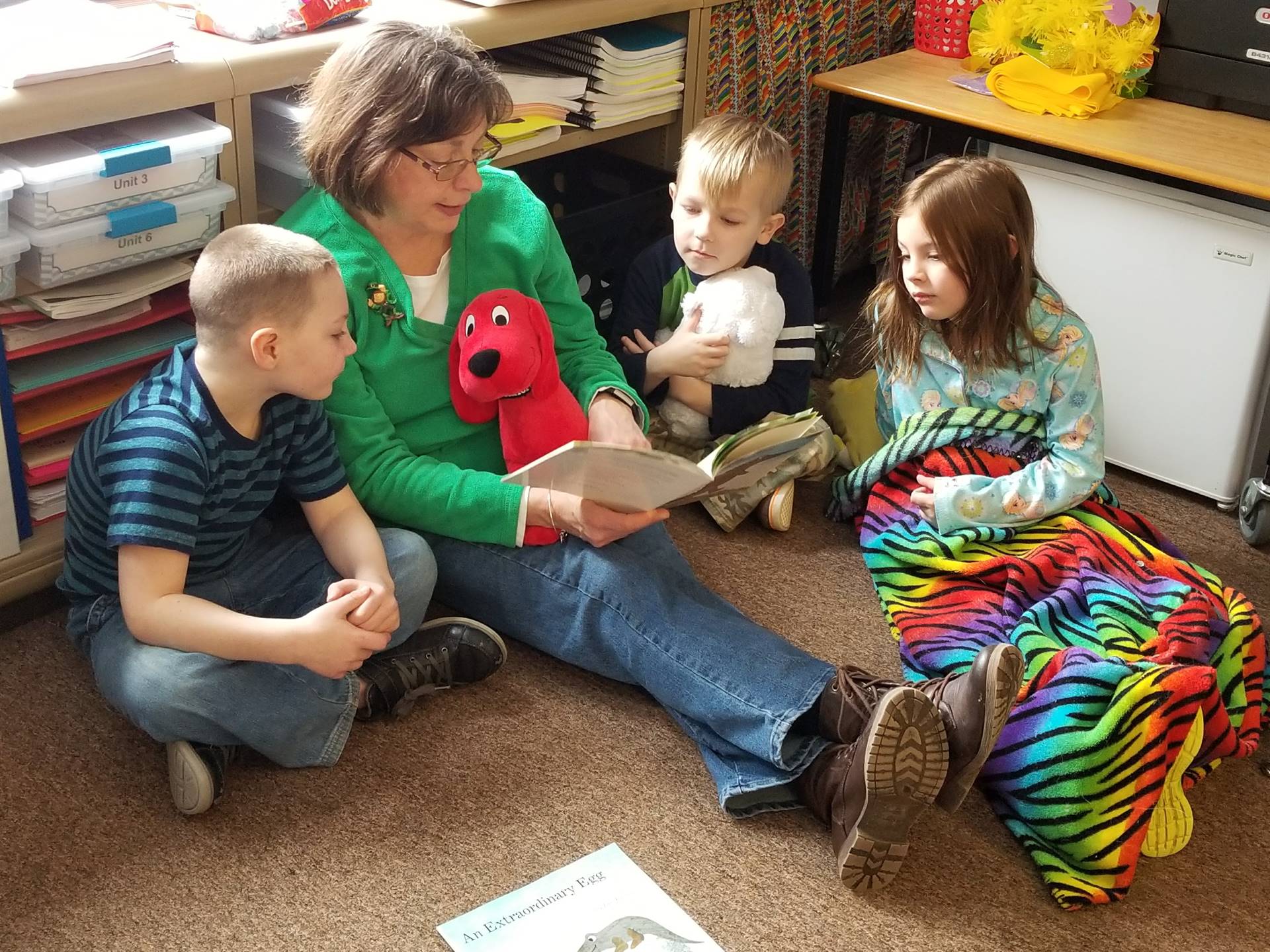 An aide reads to children during read a loud.