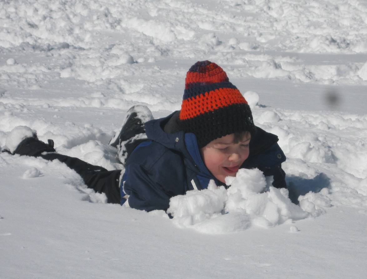 Child tastes snow.