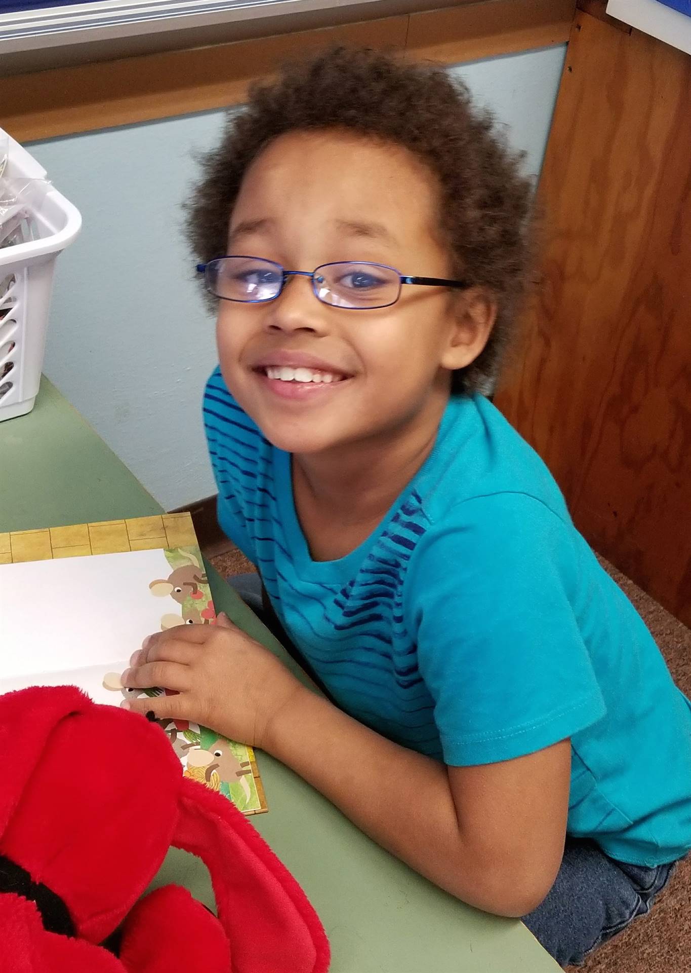 Student smiles with book.