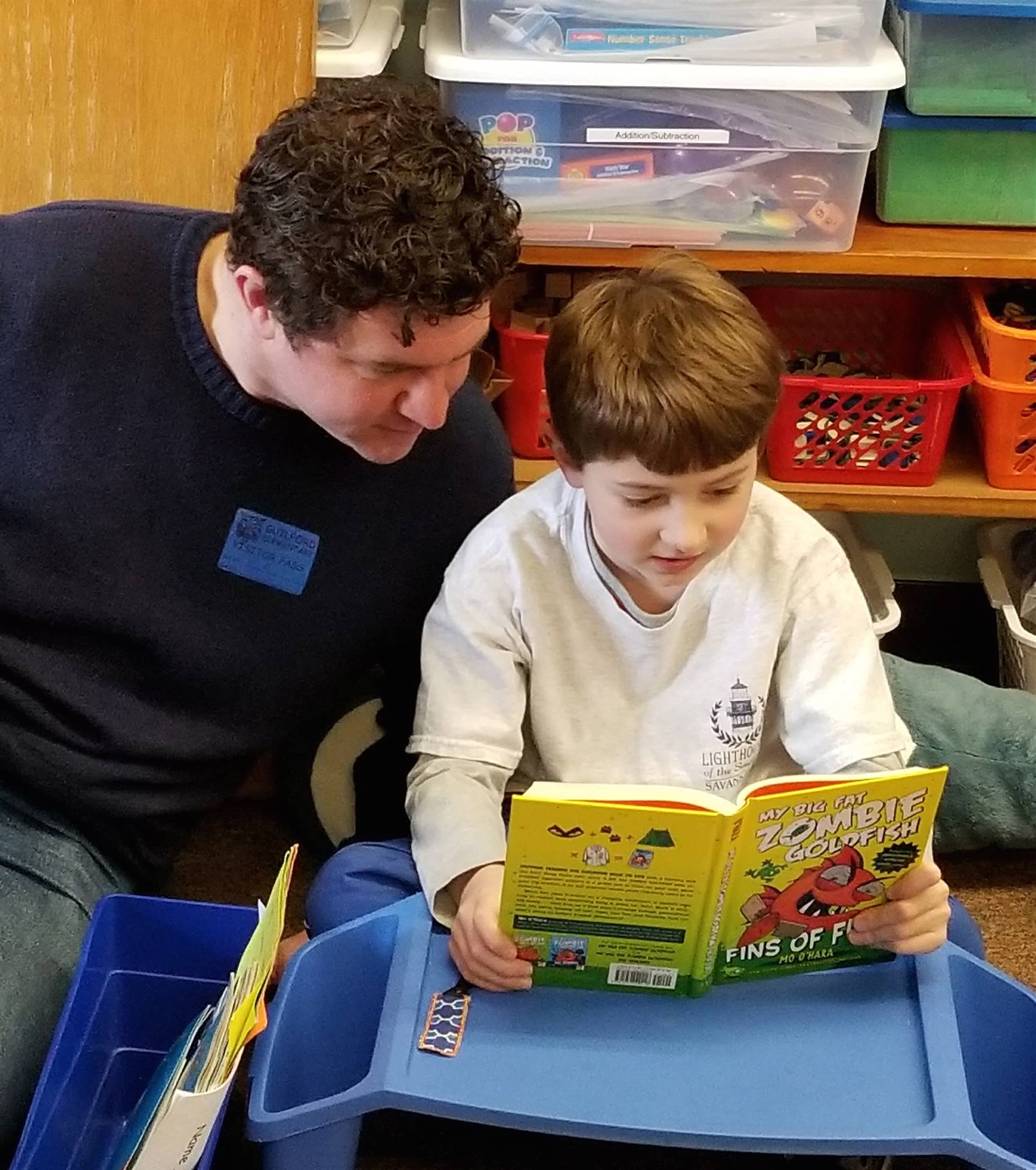 Father and son read together for read-in.