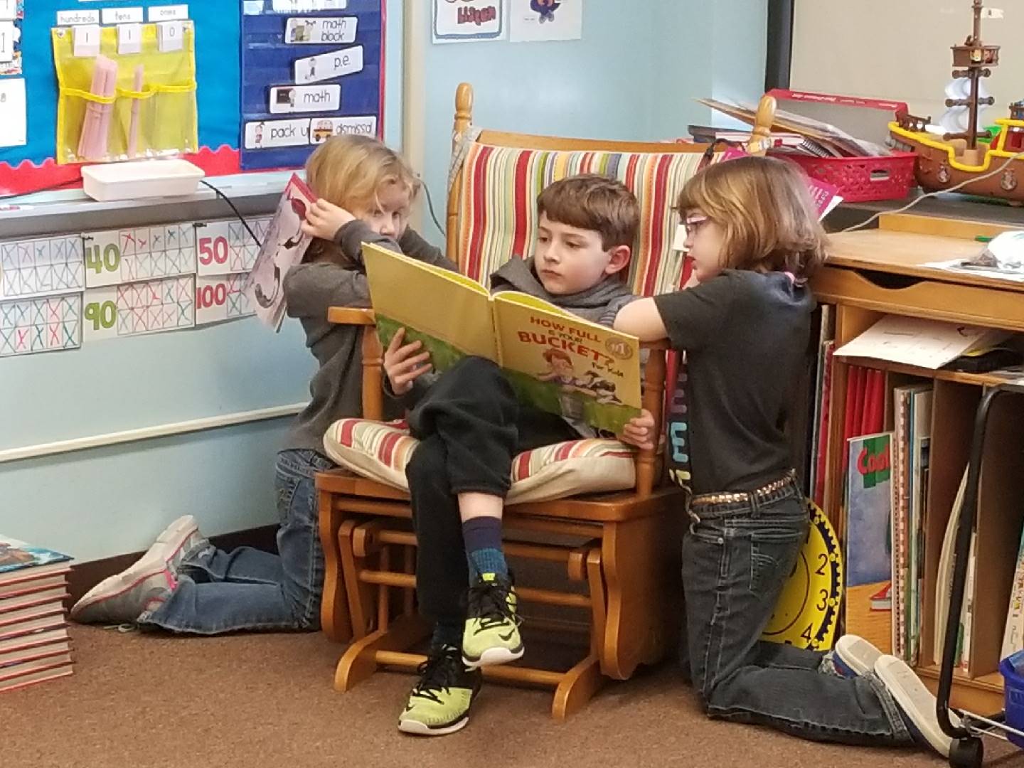 3 Students read together. 