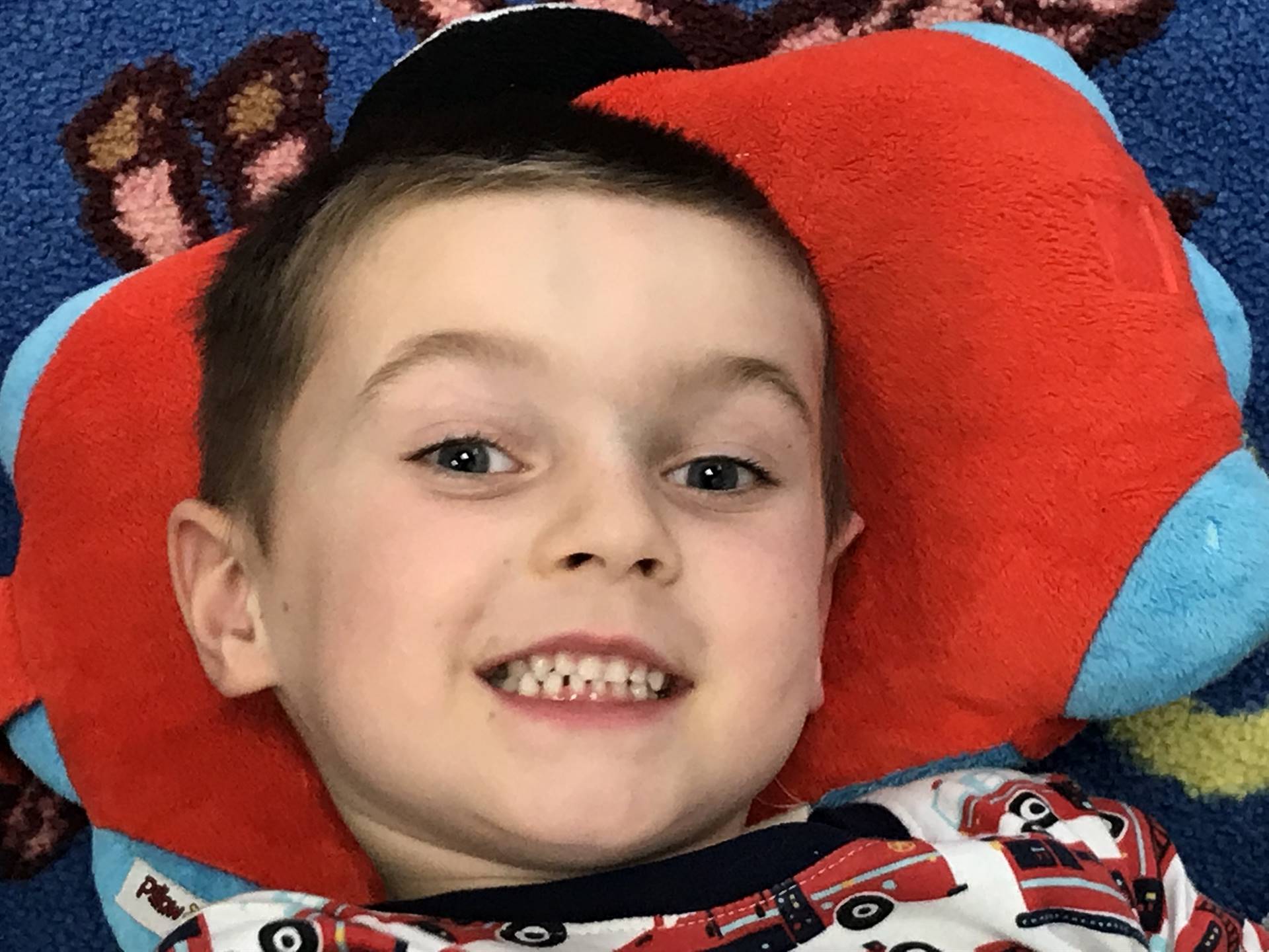 Kindergarten student lays back to listen to a book.