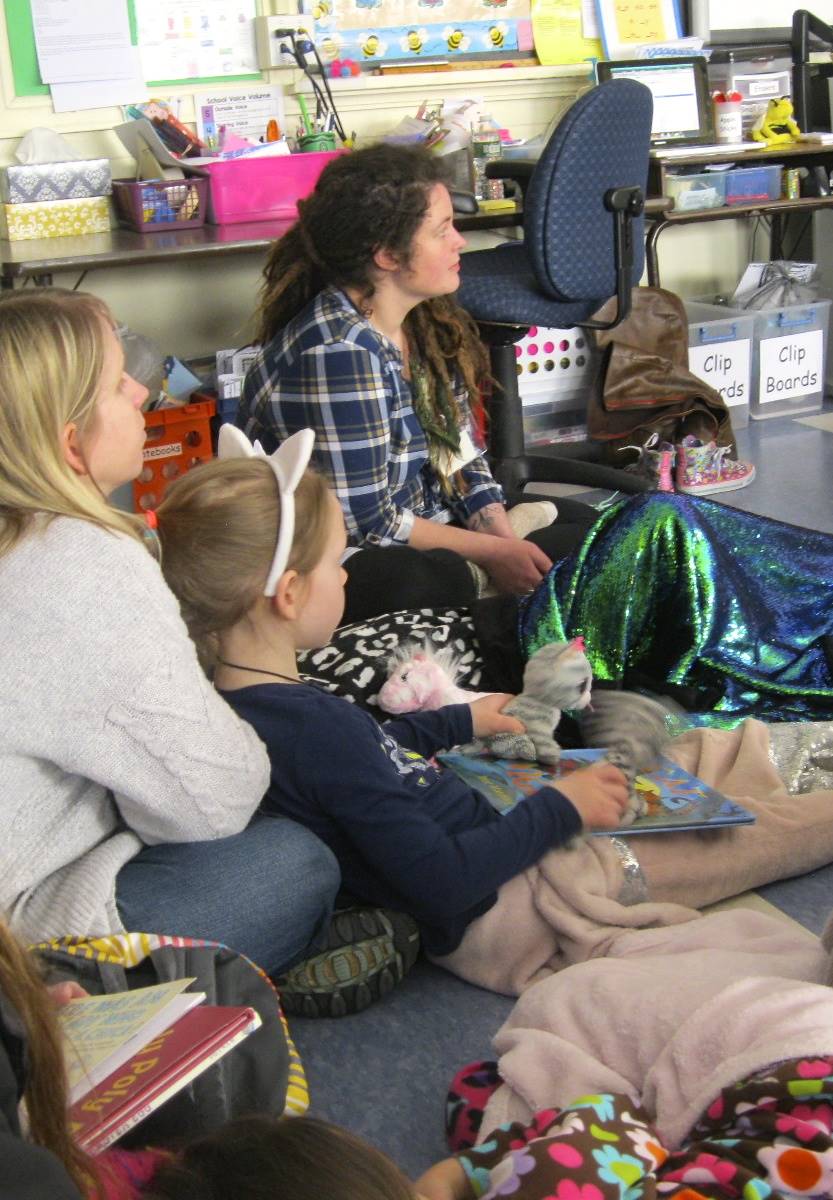 Students cozy up together to listen to a book.