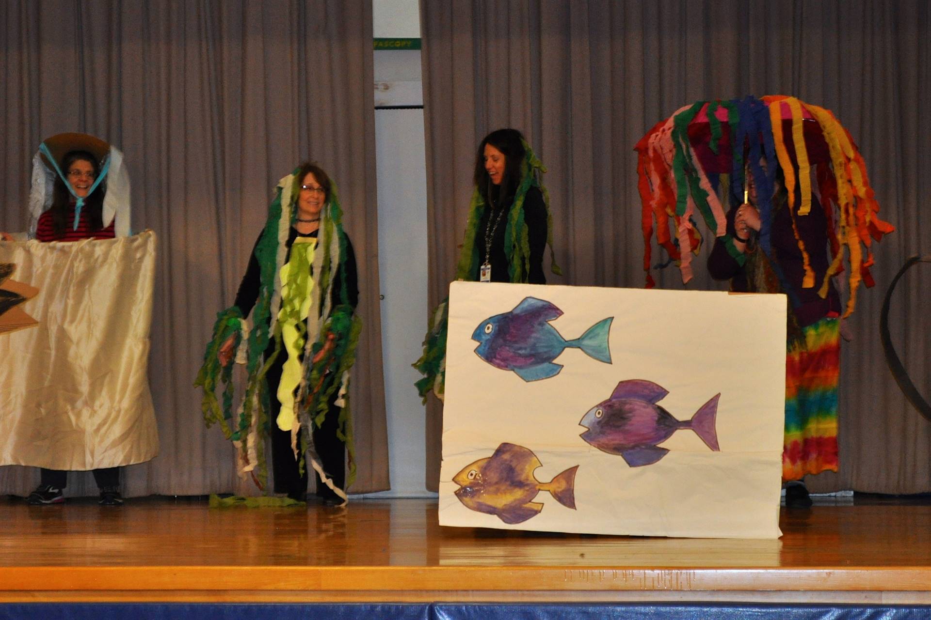 Teachers on stage acting out "Swimmy". 