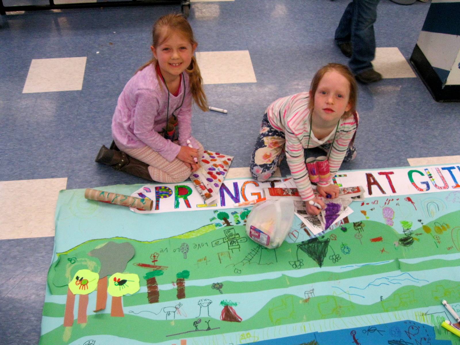 Two first graders color at the Guilford Art Fair