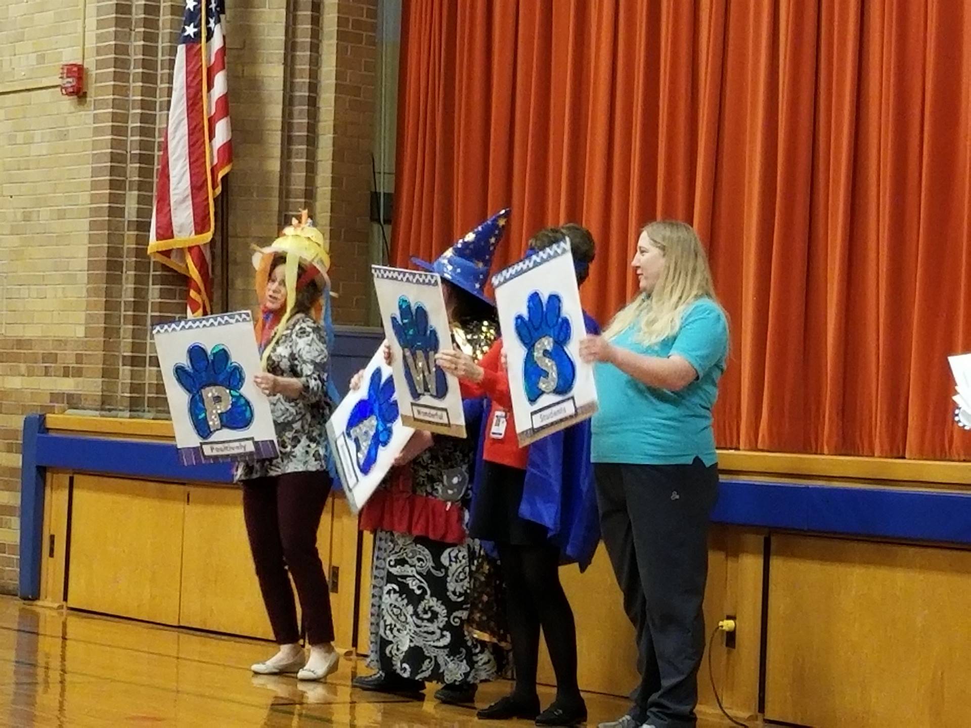 Adults holding "PAWS" sign