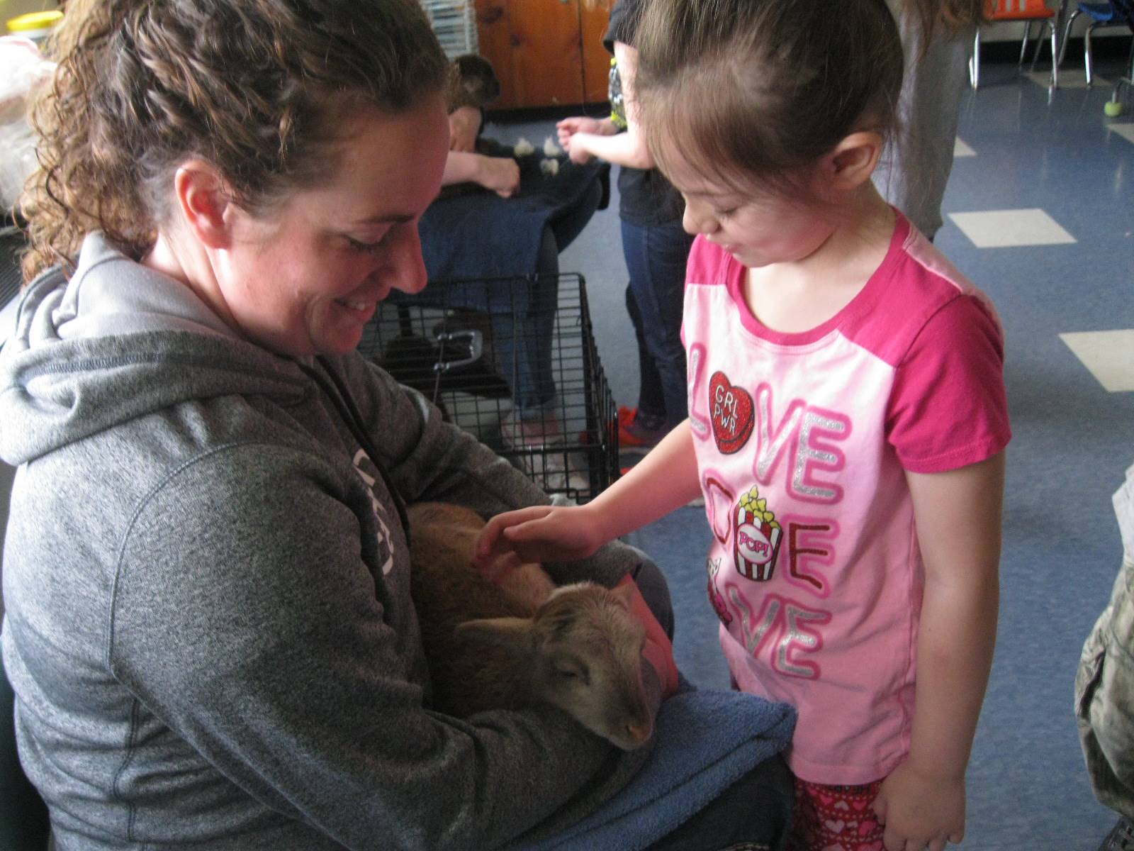 student petting lamb.