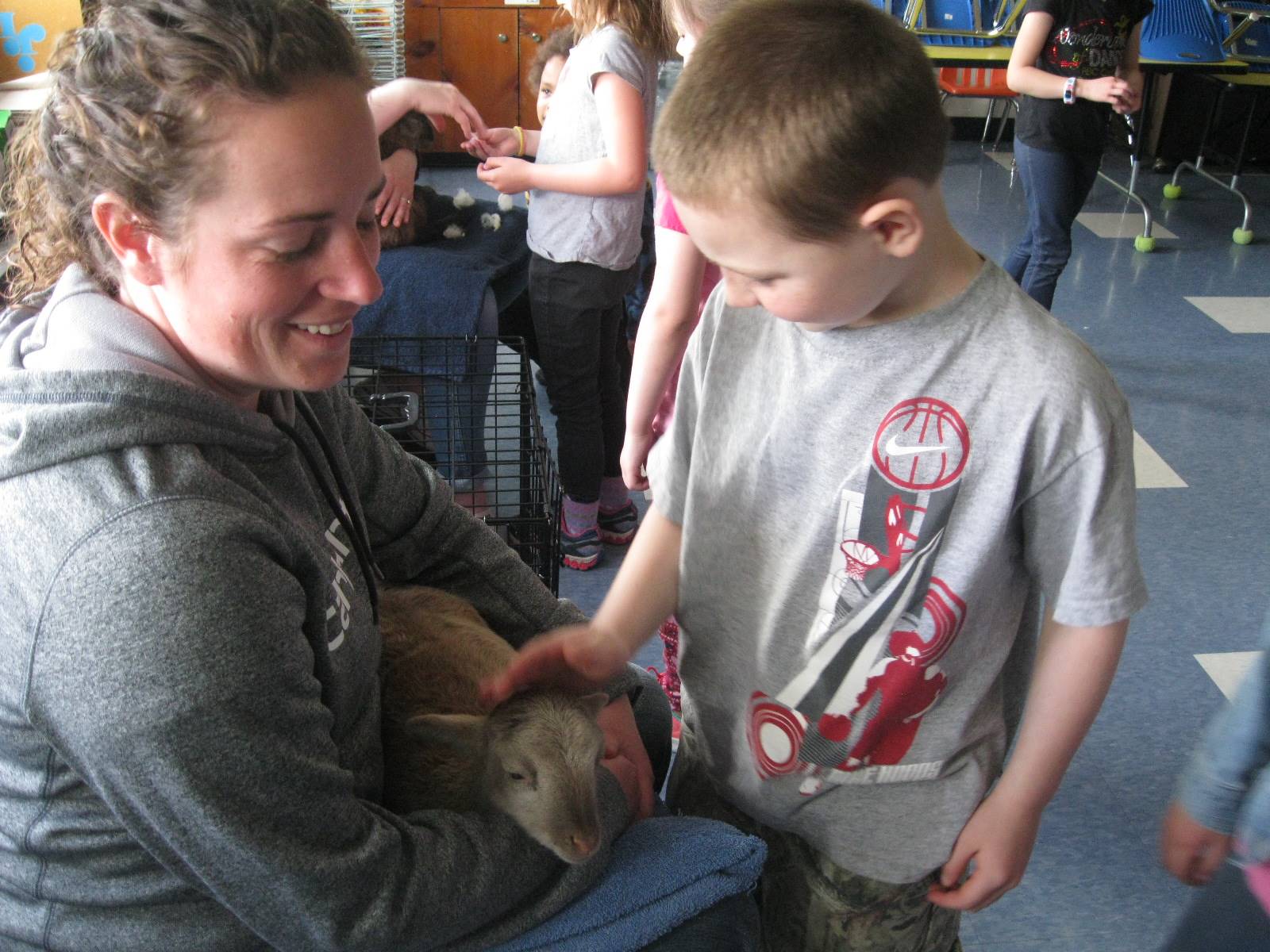 student petting lamb for Ag. Day.