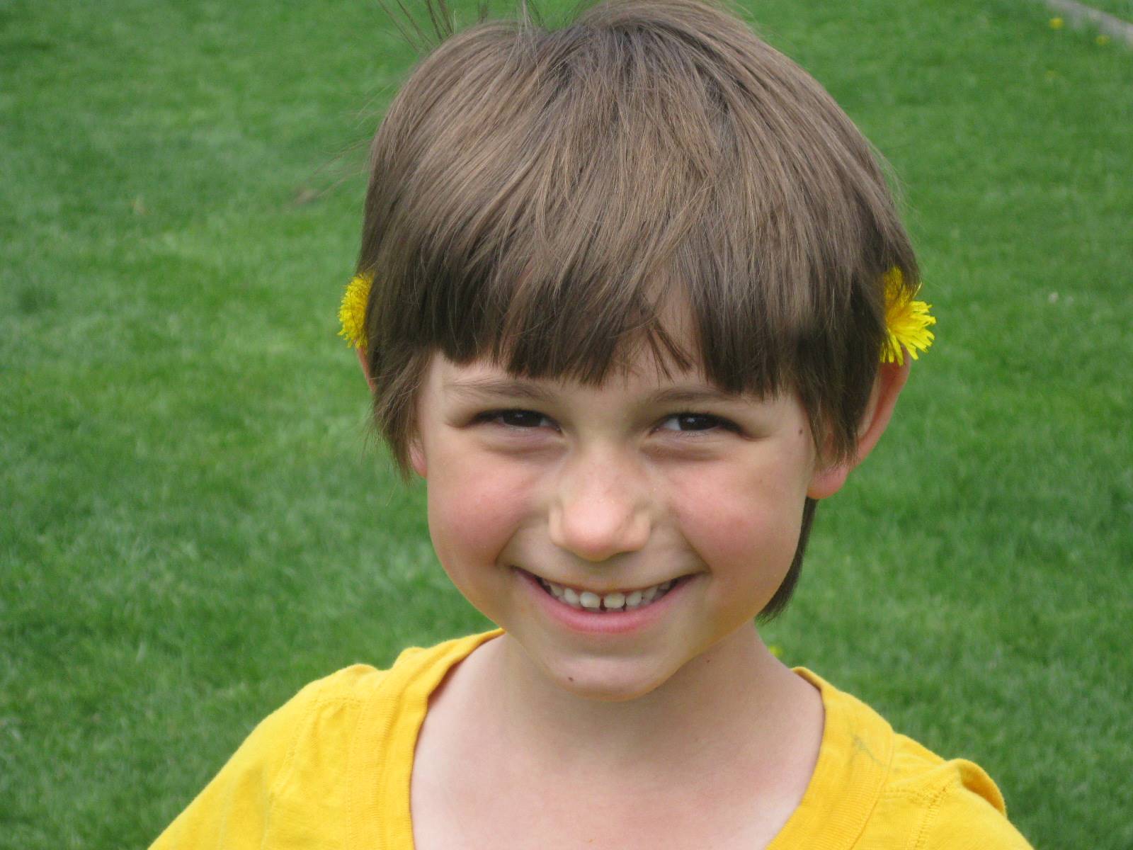 Child with dandelion decorations.