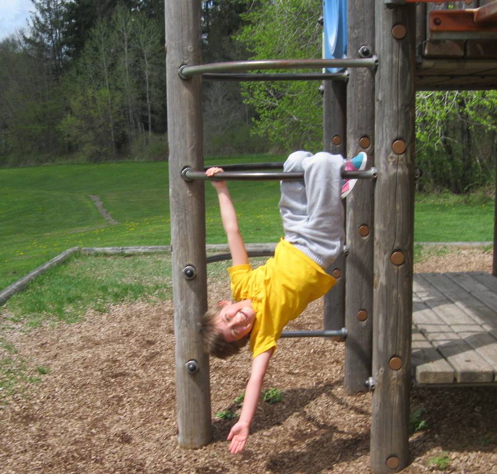 student hanging on the monkey bars.