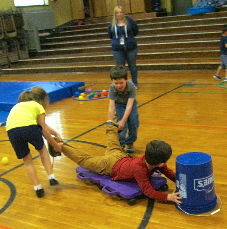 Kindergartners work together on a scooter.