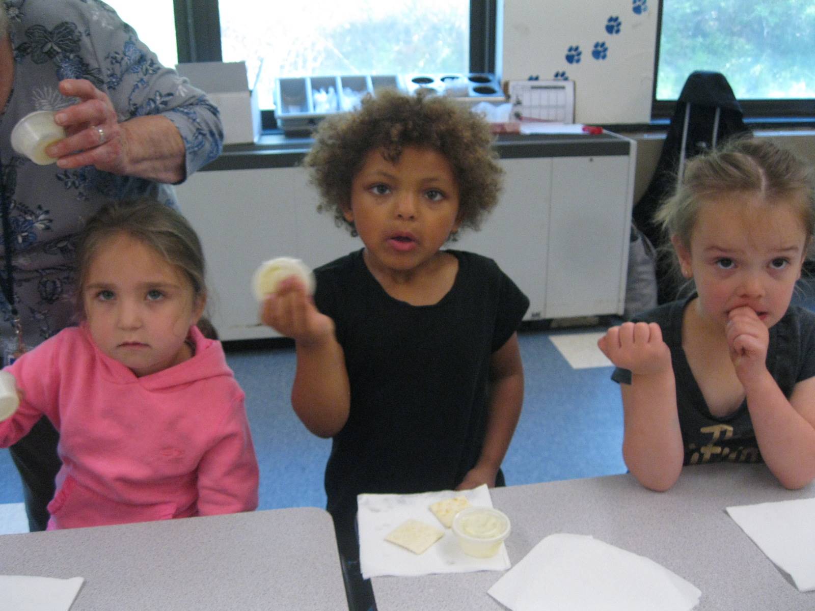 Three students shake a container of cream to make butter.