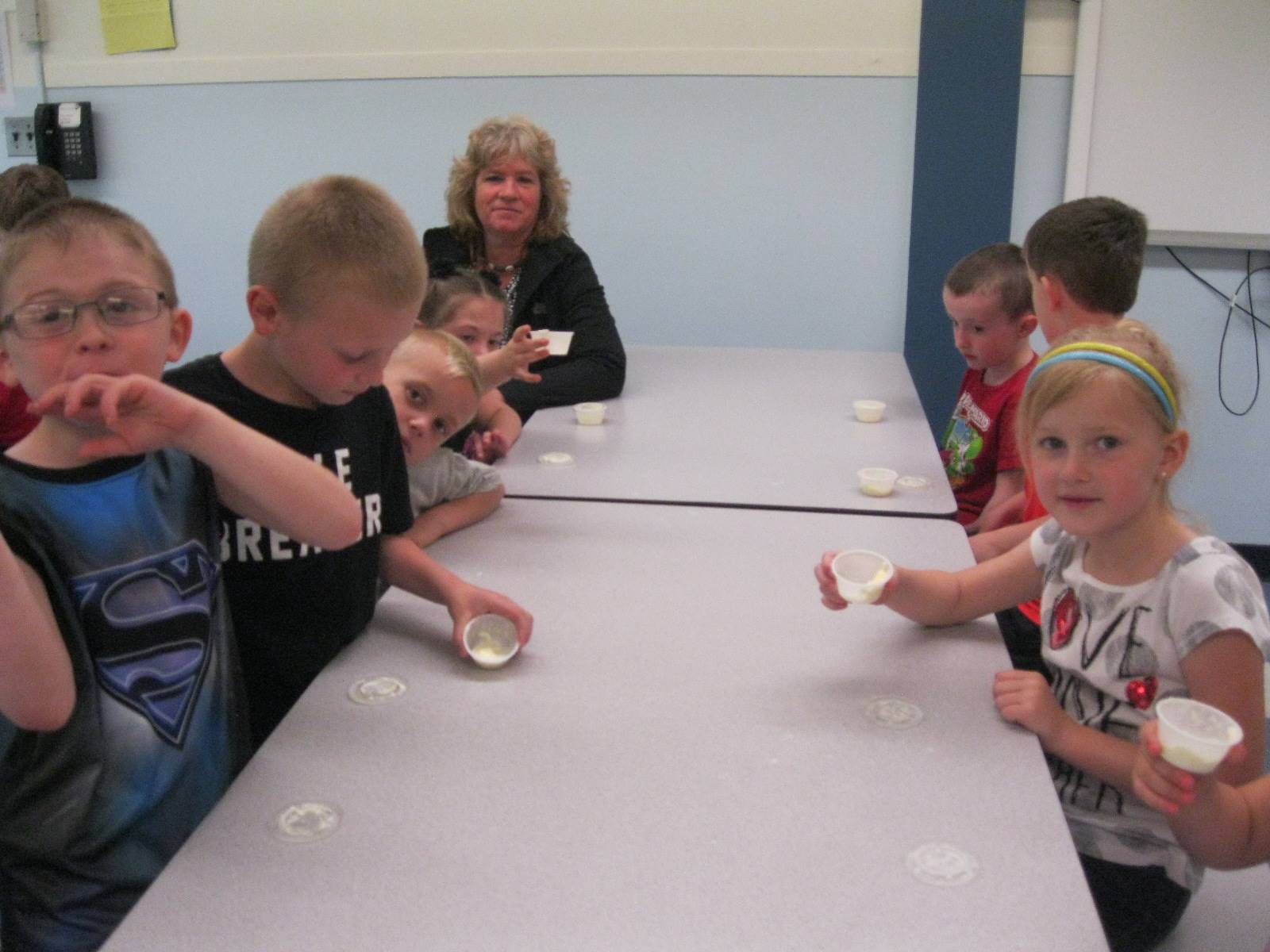 Students shake containers of cream to make butter.