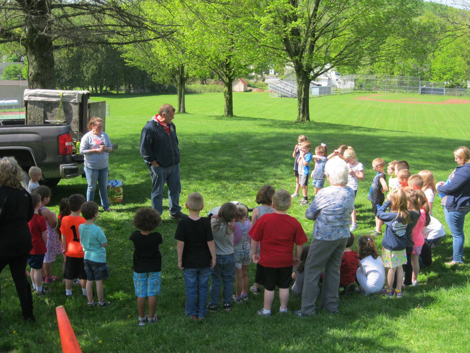 kindergartners listen to a farmer talk about  a calf