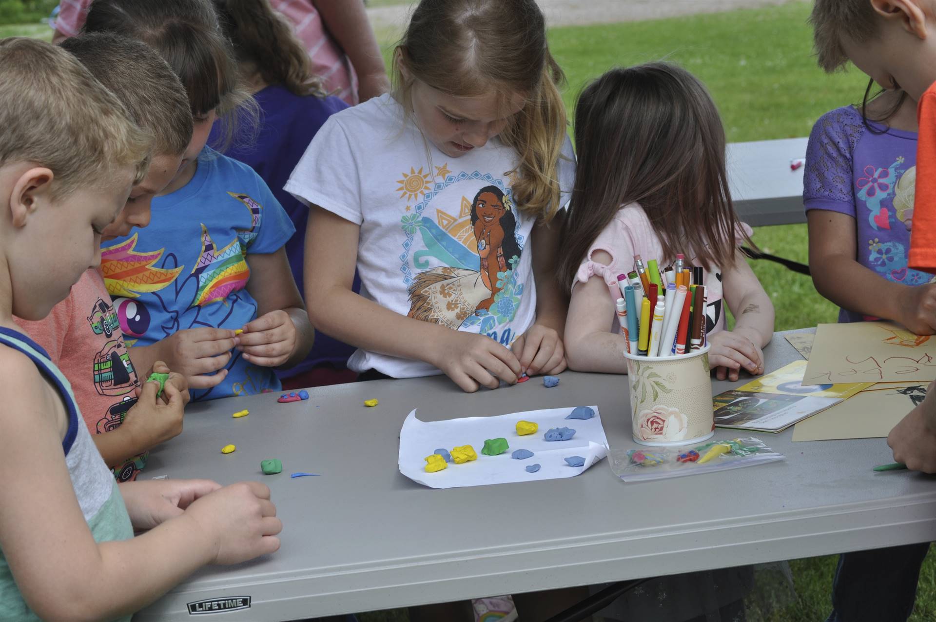 Students create clay bugs at the campout bug station