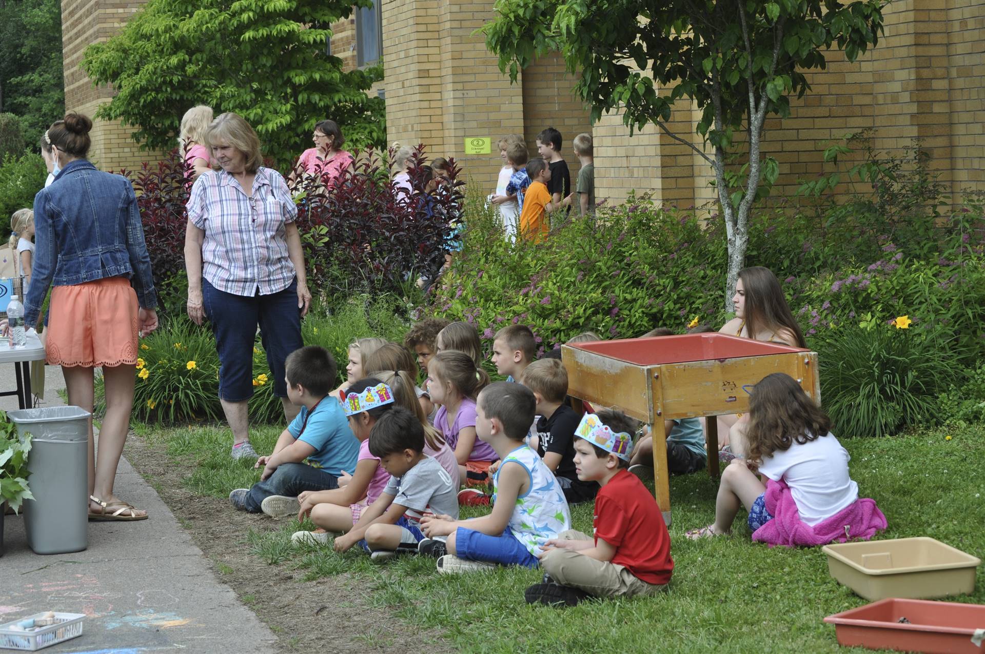 Students listen to teacher at art station