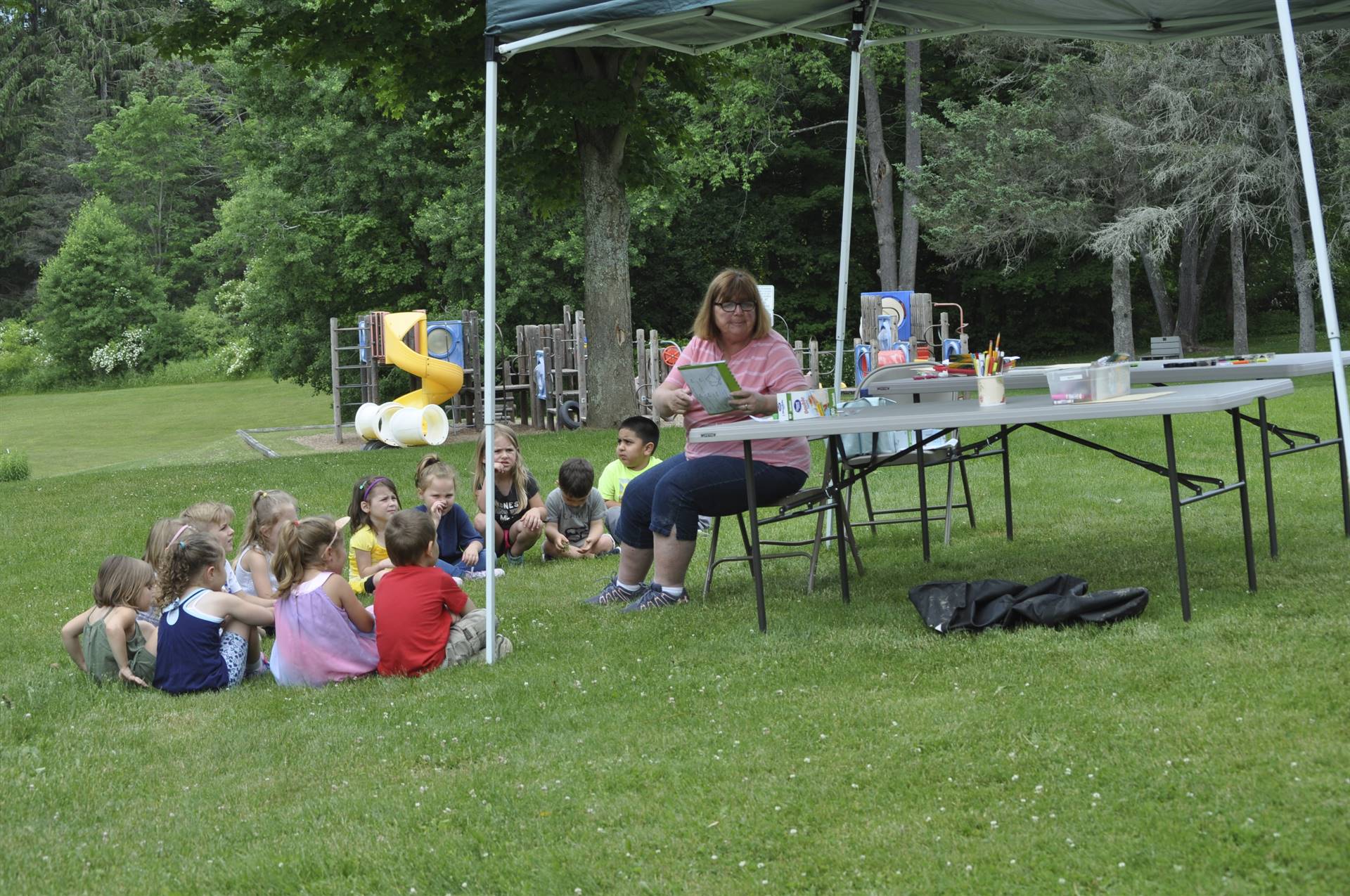 students find out about bugs from the bug station adult.