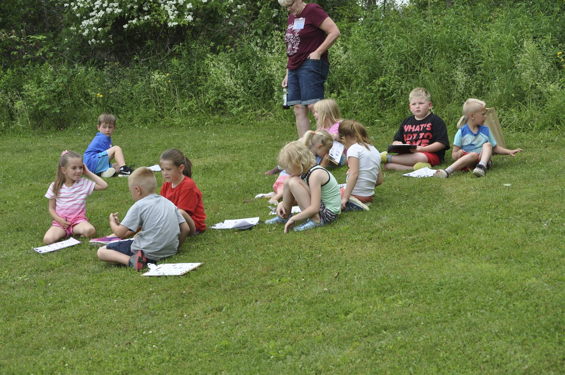 students rest from hiking on a bank.