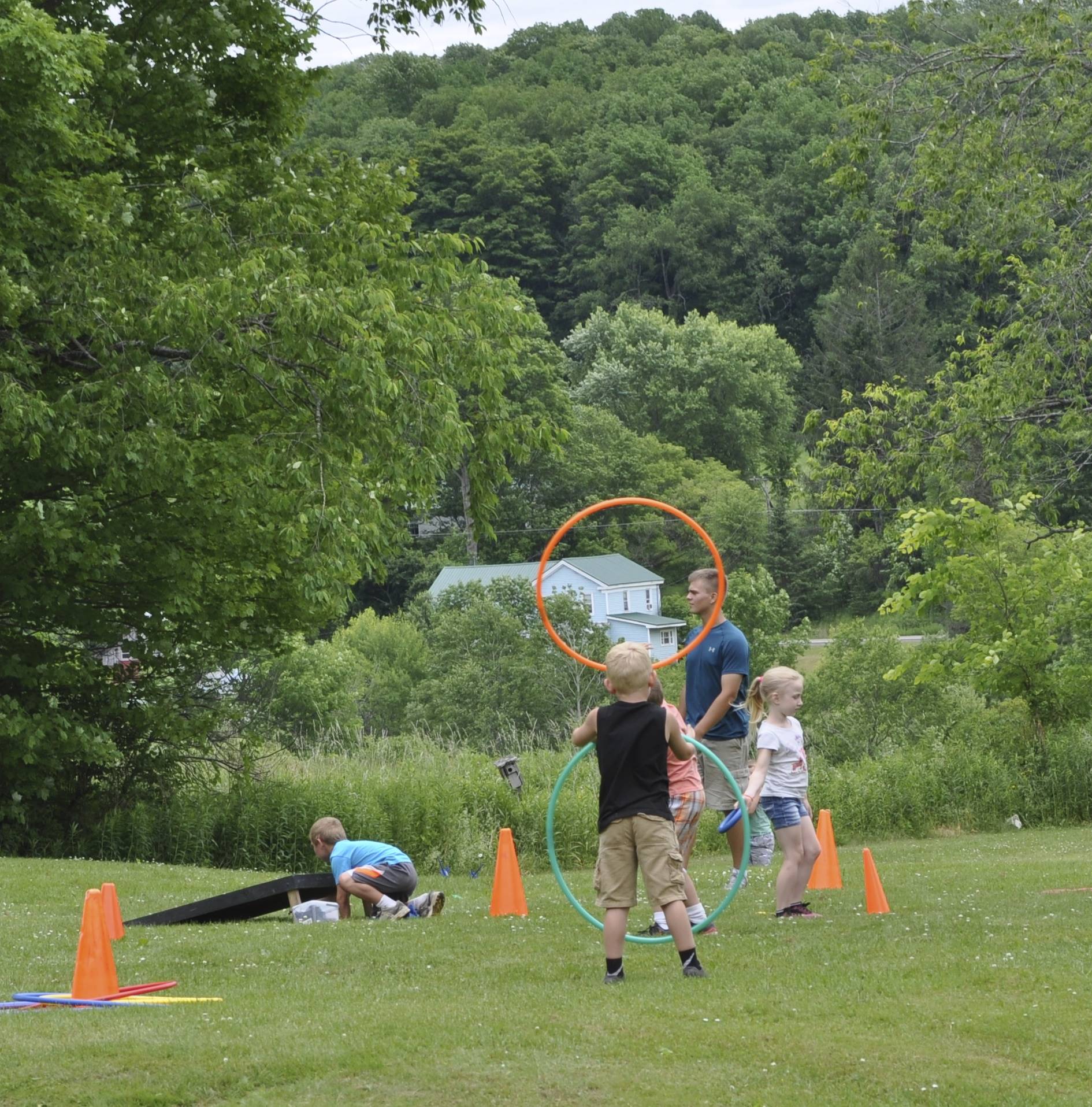 students try hula hooping outside.