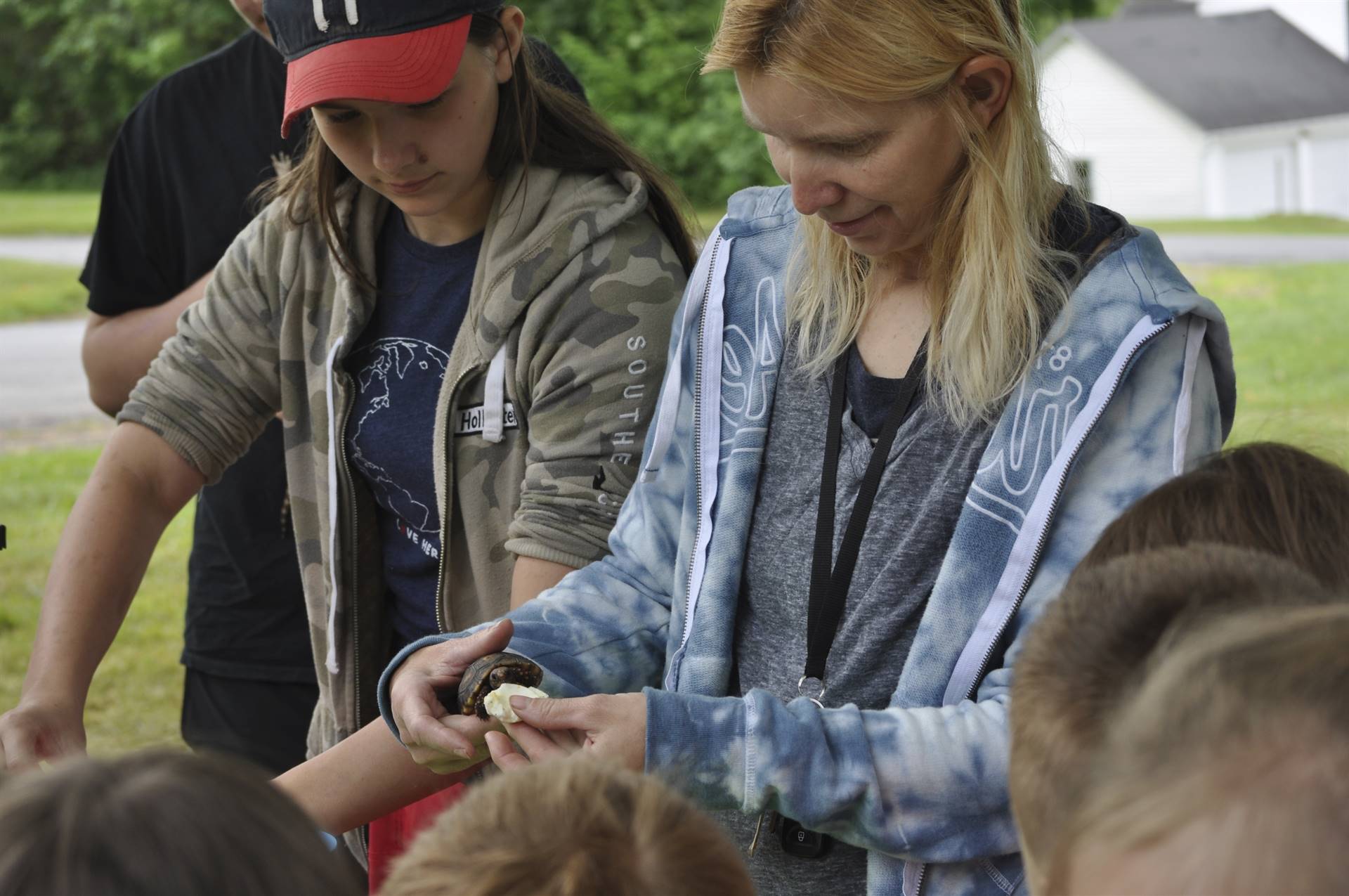 Adult showing students a turtle.