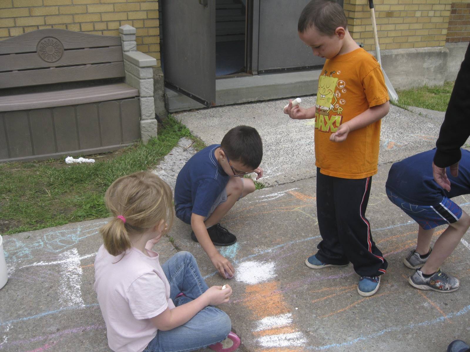 students using chalk on the sidewalk at campout.