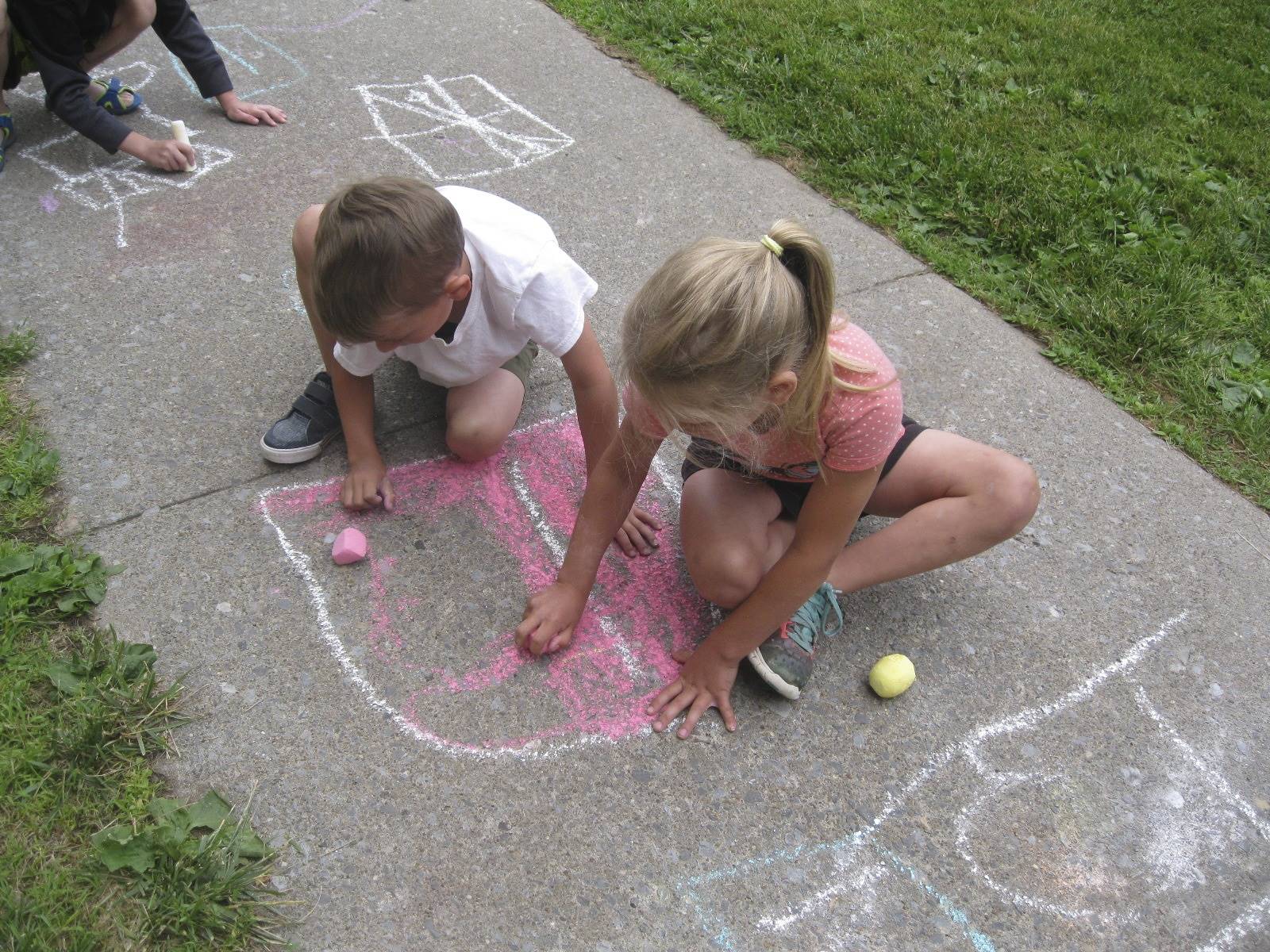 students using chalk on the sidewalk at campout.